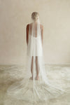 A model wearing the ELLA I minimalist one tier wedding veil in chapel length ivory colour