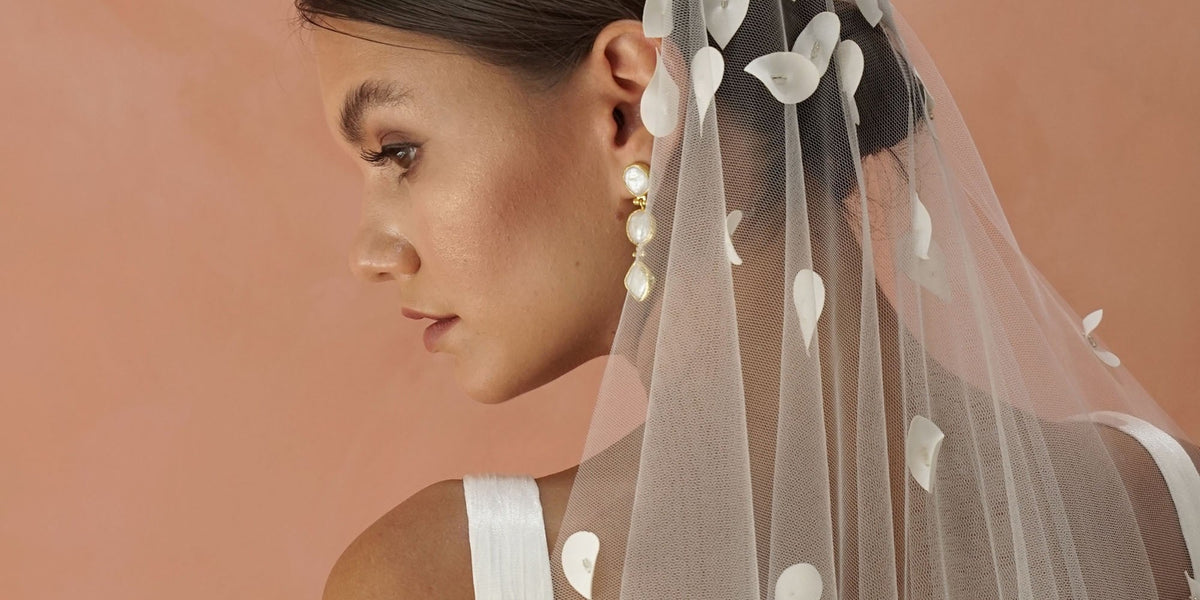 model wears a one tier floral veil with petal flowers