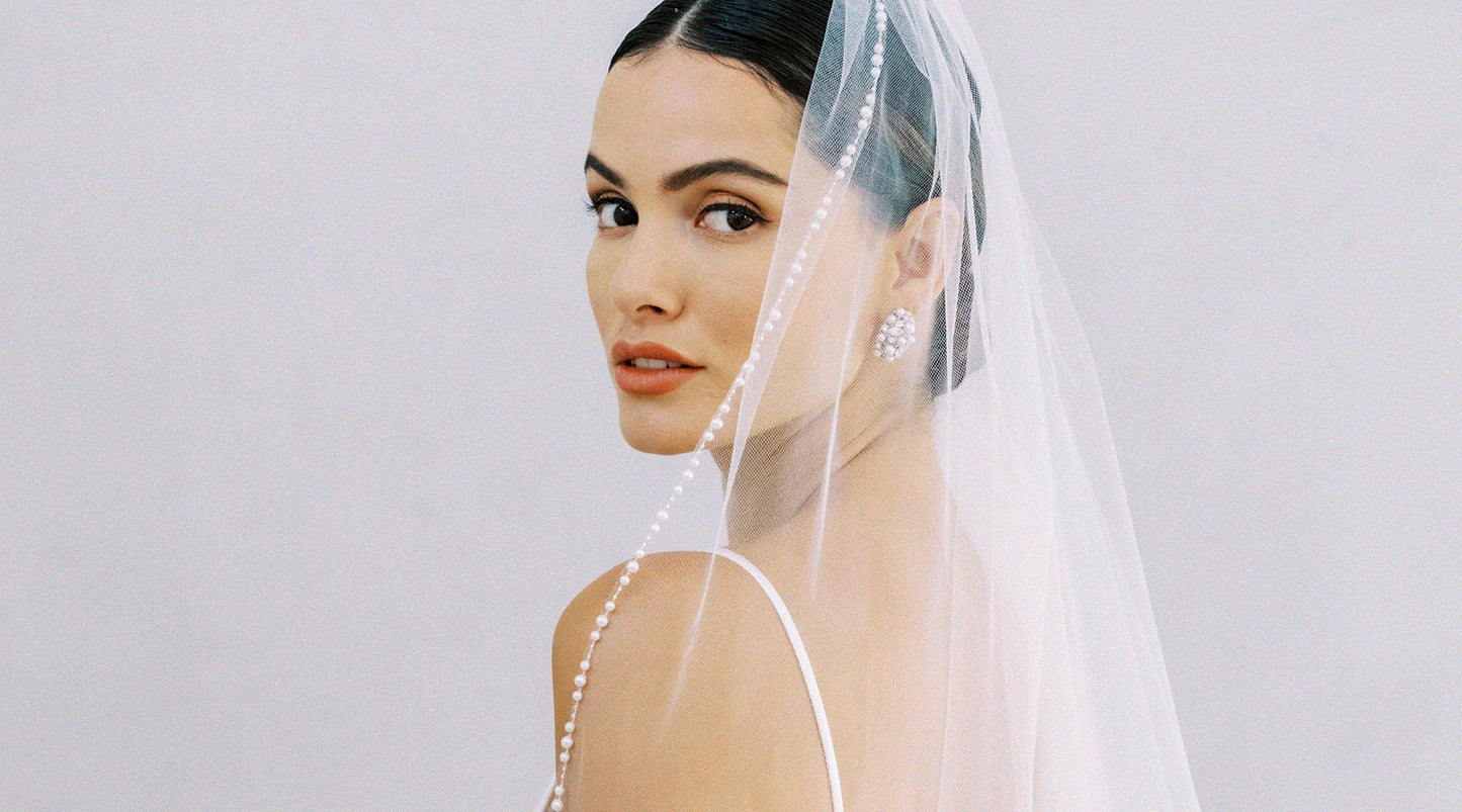 A bride wearing a pearl edge wedding veil