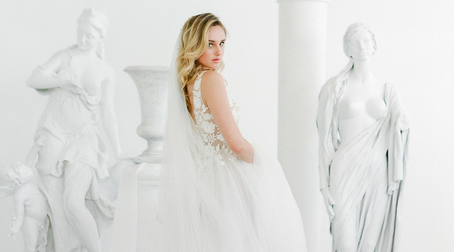 A bride wearing a lace wedding dress and a pearl wedding veil by Madame Tulle bridal