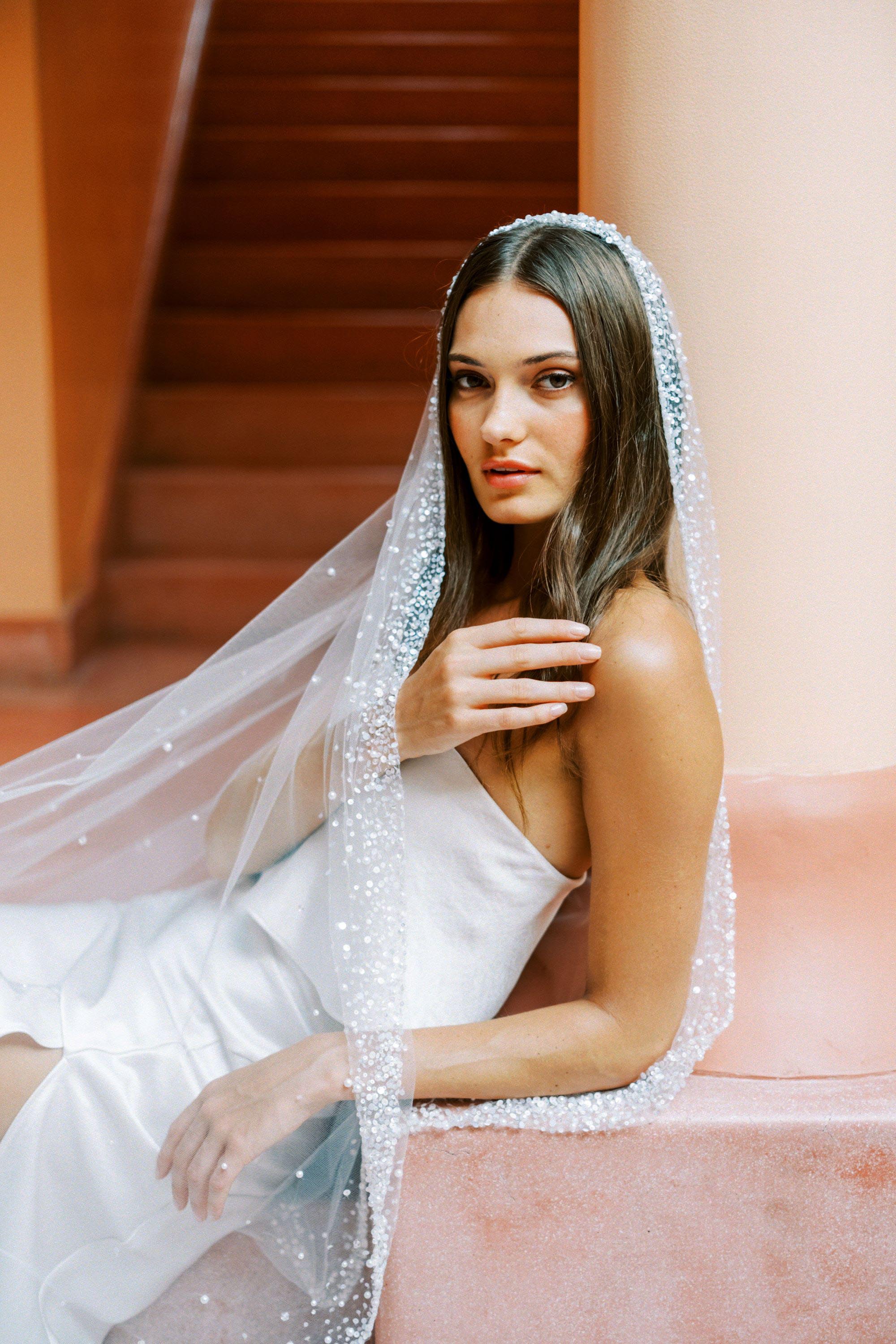 Model wears a mantilla wedding veil, one tier veil with beads and sequins.