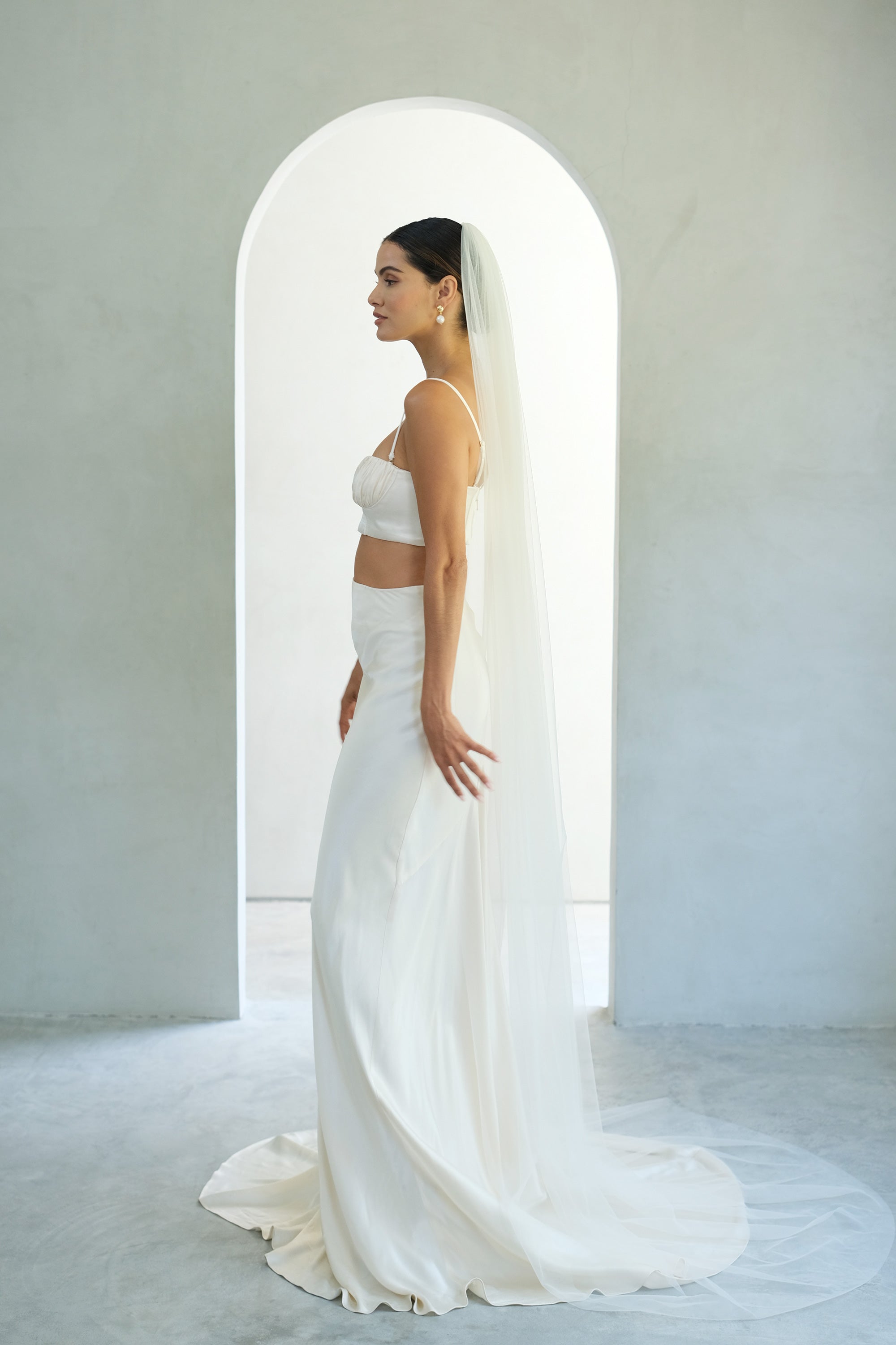 Full length side view of bride wearing long plain veil in soft tulle
