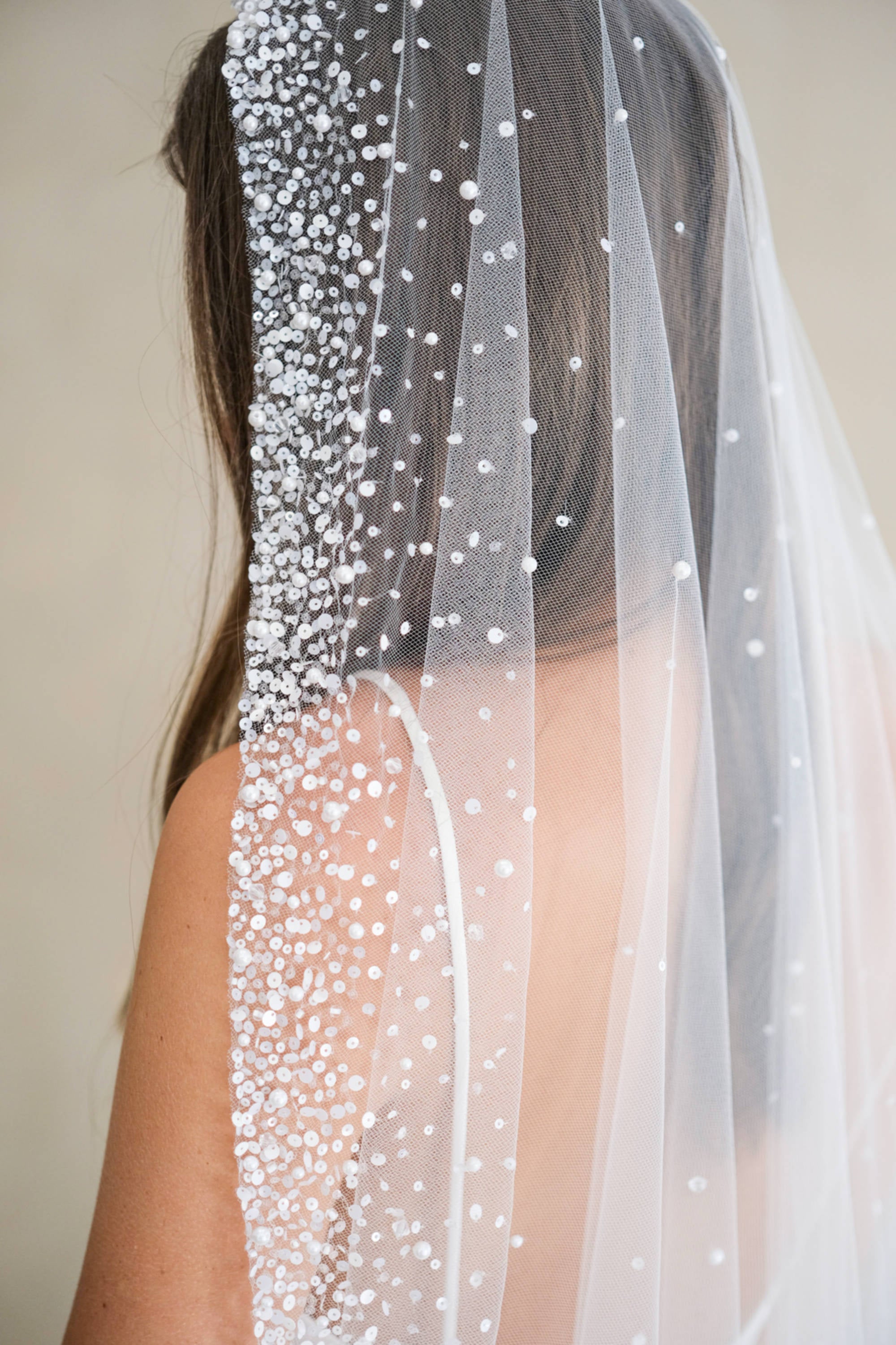 Model wears a mantilla wedding veil, one tier veil with beads and sequins.
