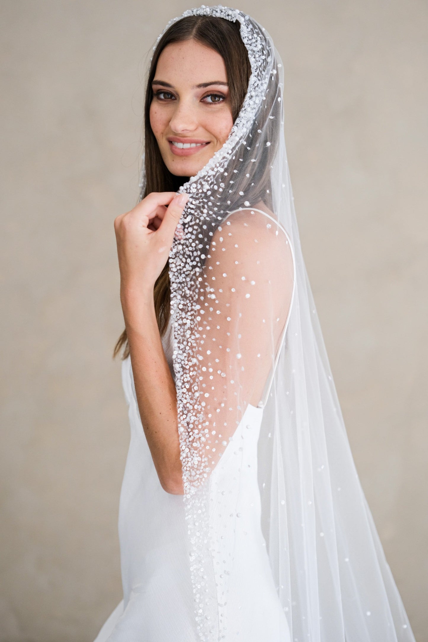 Model wears a mantilla wedding veil, one tier veil with beads and sequins.