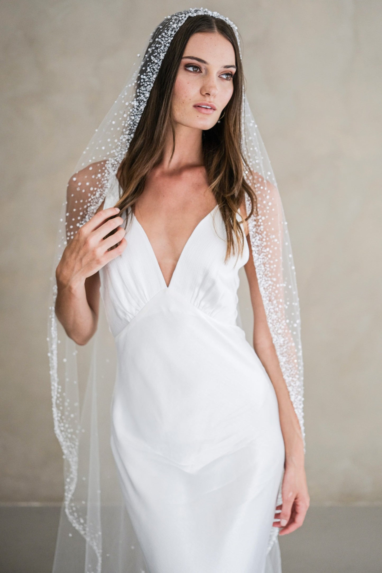 Model wears a mantilla wedding veil, one tier veil with beads and sequins.