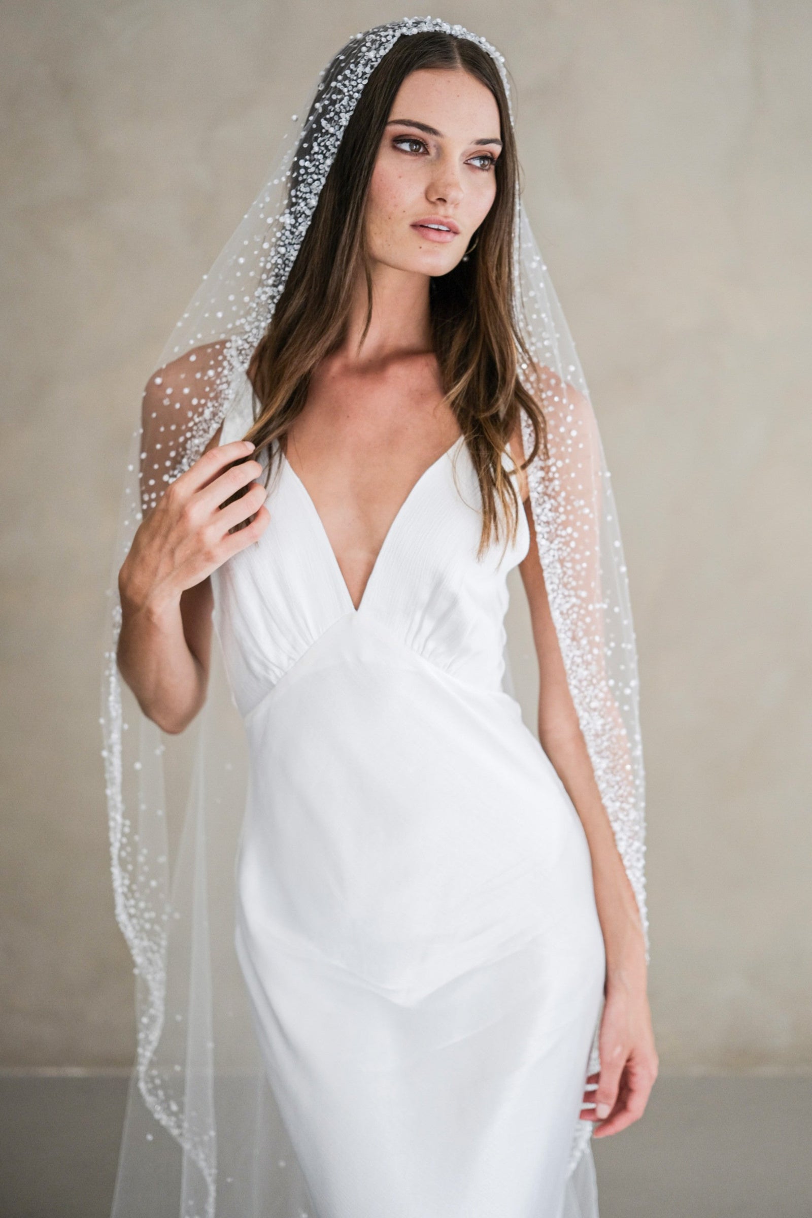 Model wears a mantilla wedding veil, one tier veil with beads and sequins.