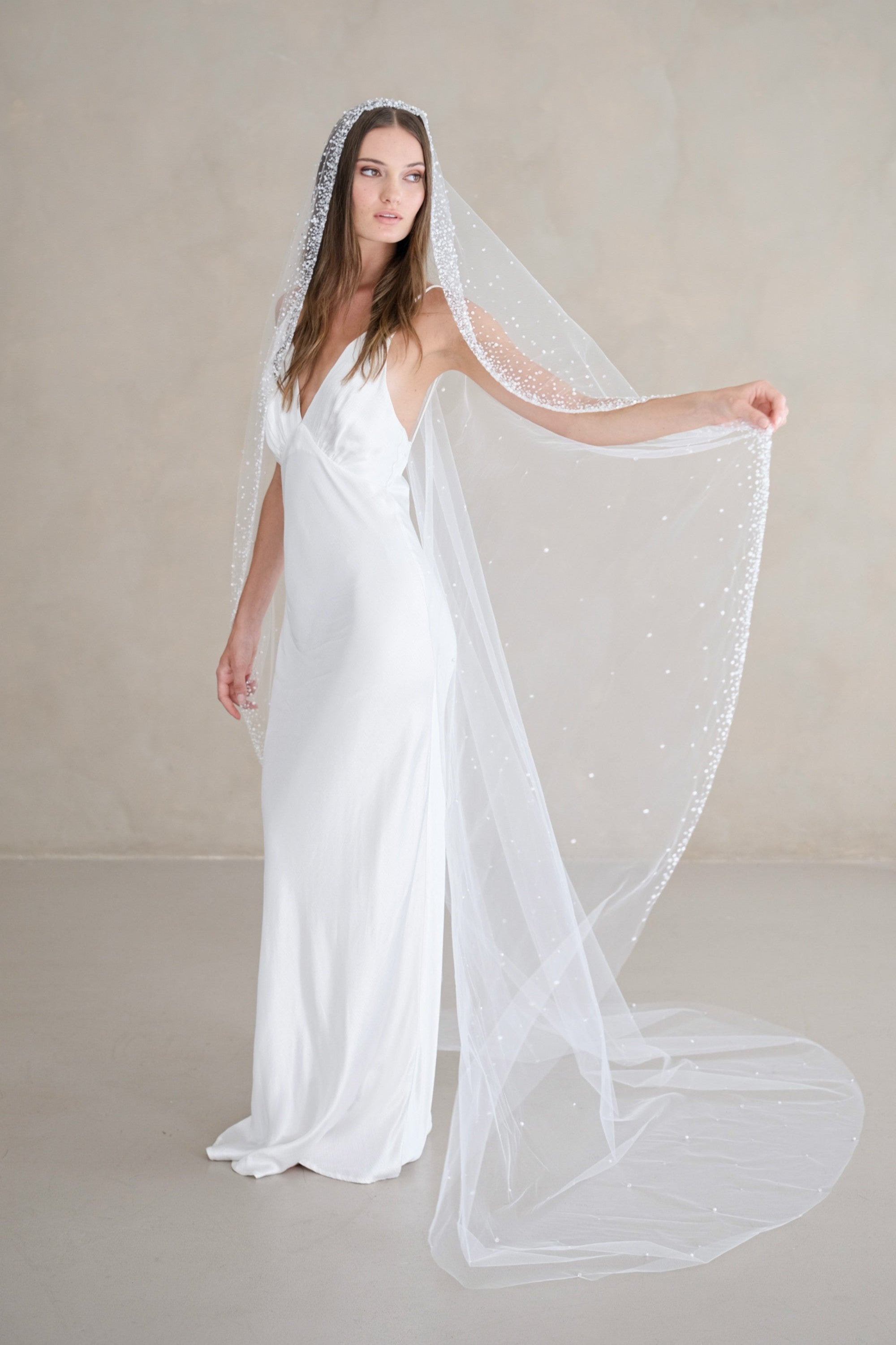 Model wears a mantilla wedding veil, one tier veil with beads and sequins.