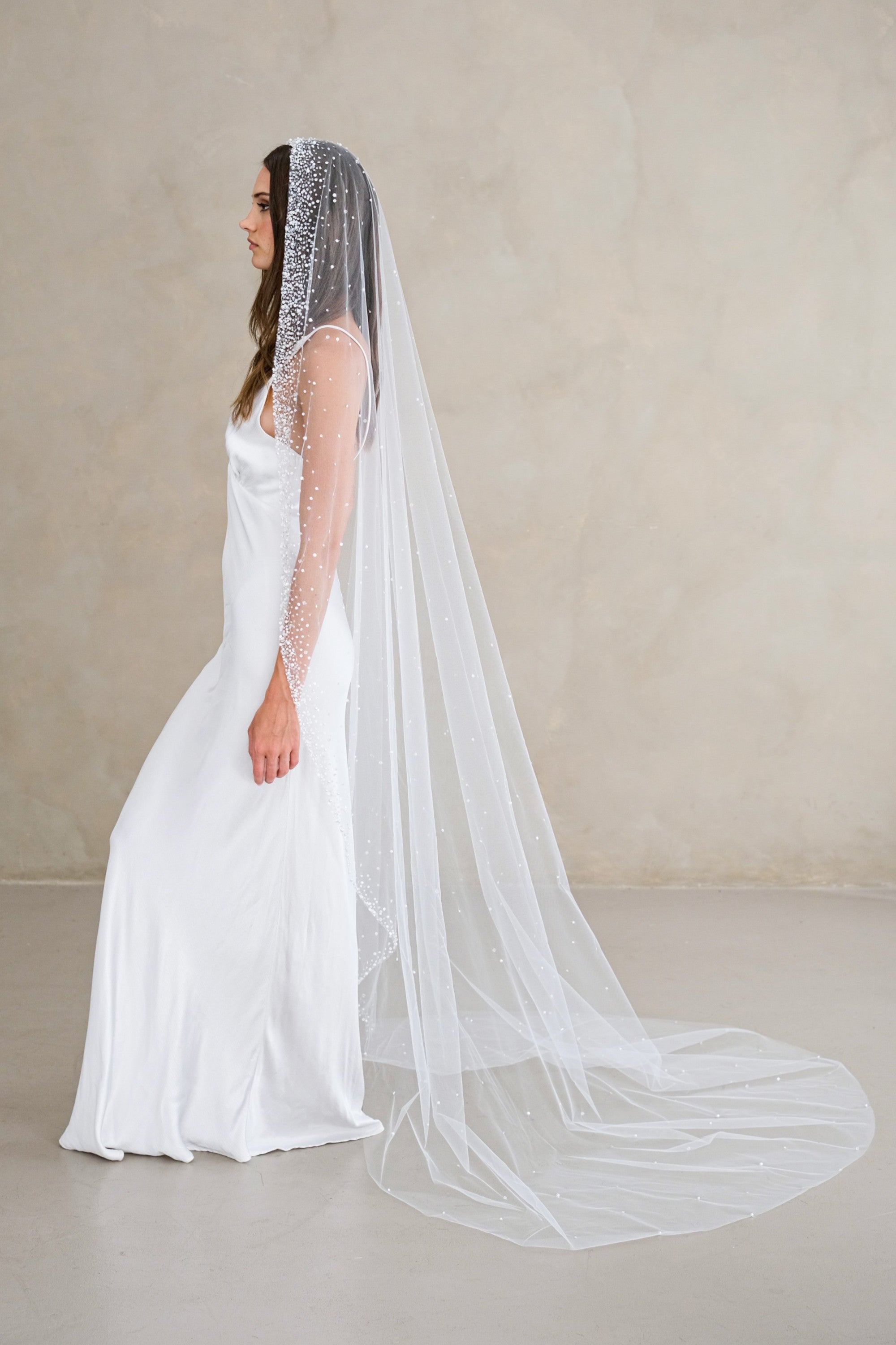 Model wears a mantilla wedding veil, one tier veil with beads and sequins.