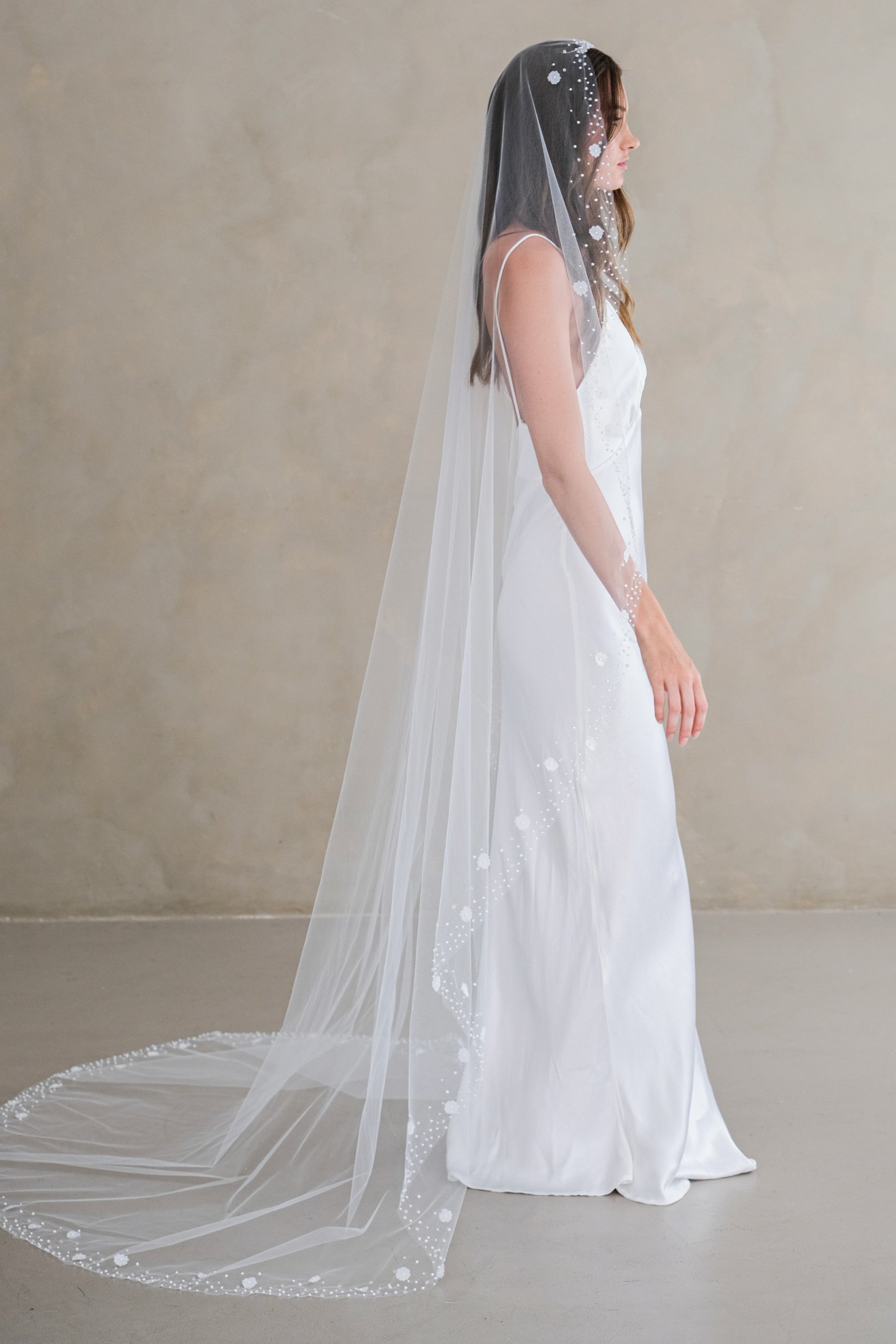 Model wears a floral wedding veil, one tier veil with pearls and fabric flowers.