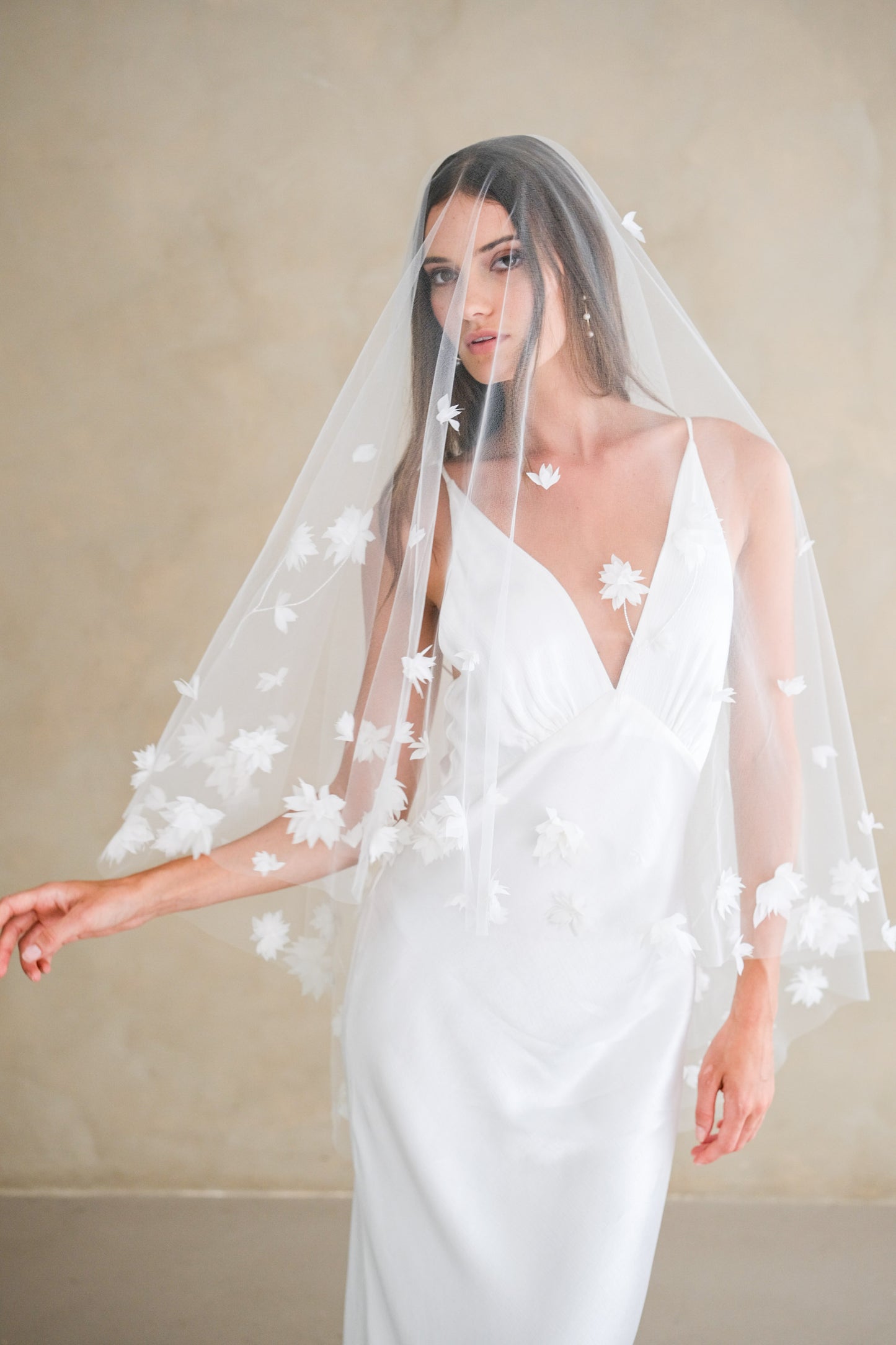 Bride models fingertip length drop veil scattered with 3-D fabric flowers