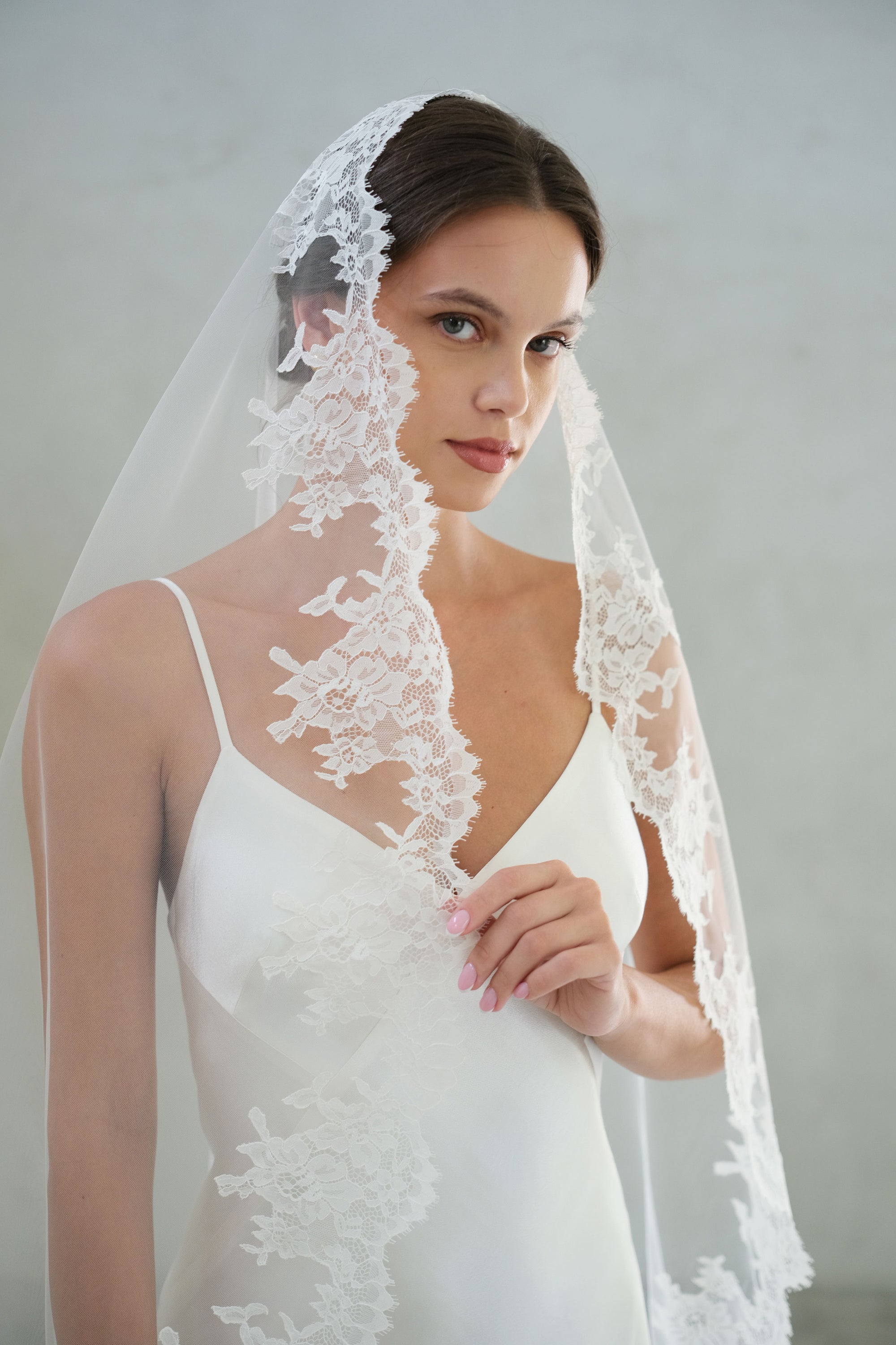 Romatic lace trimmed long veil falls over head and shoulders of bride