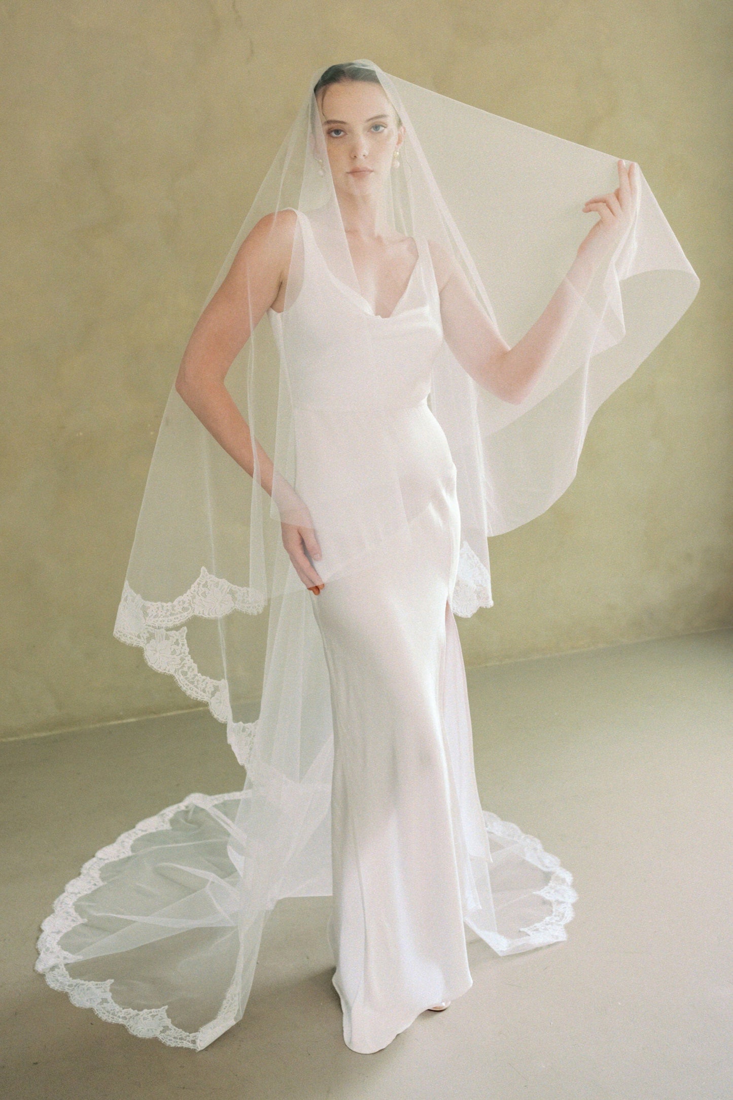 model wears a drop veil with partial lace trim