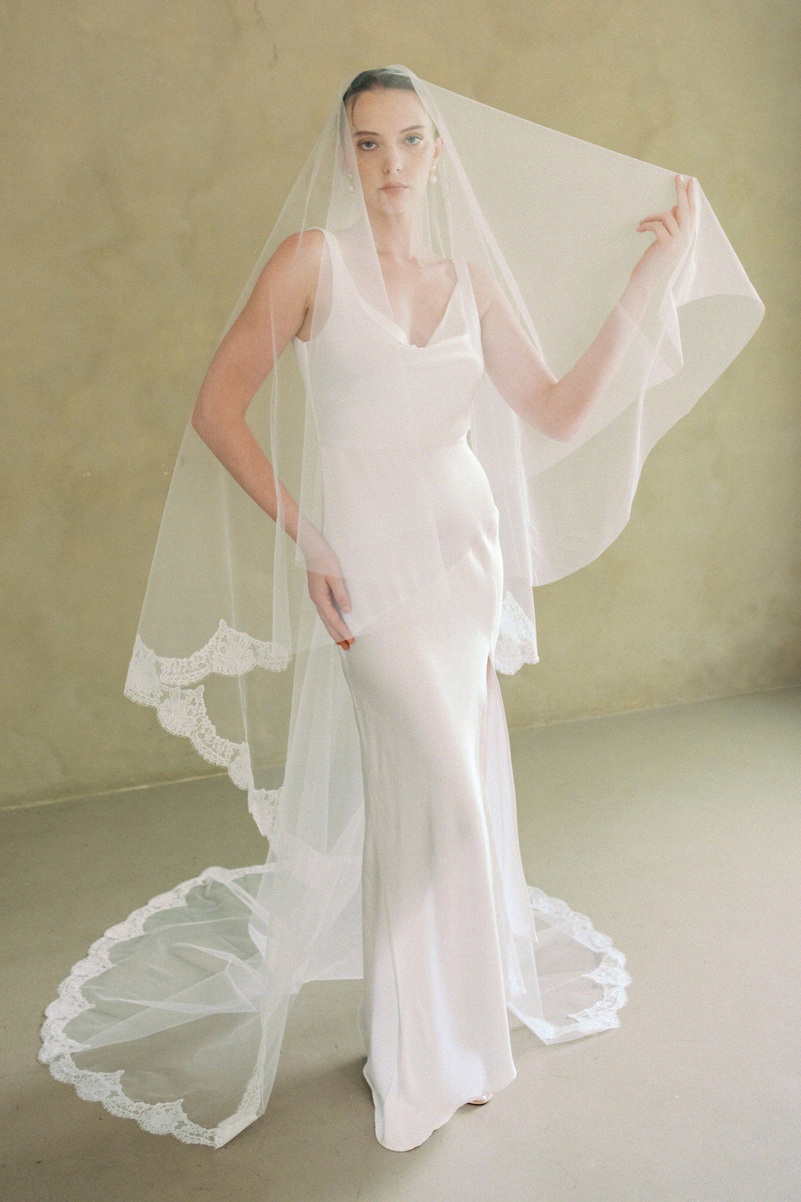 model wears a drop veil with partial lace trim