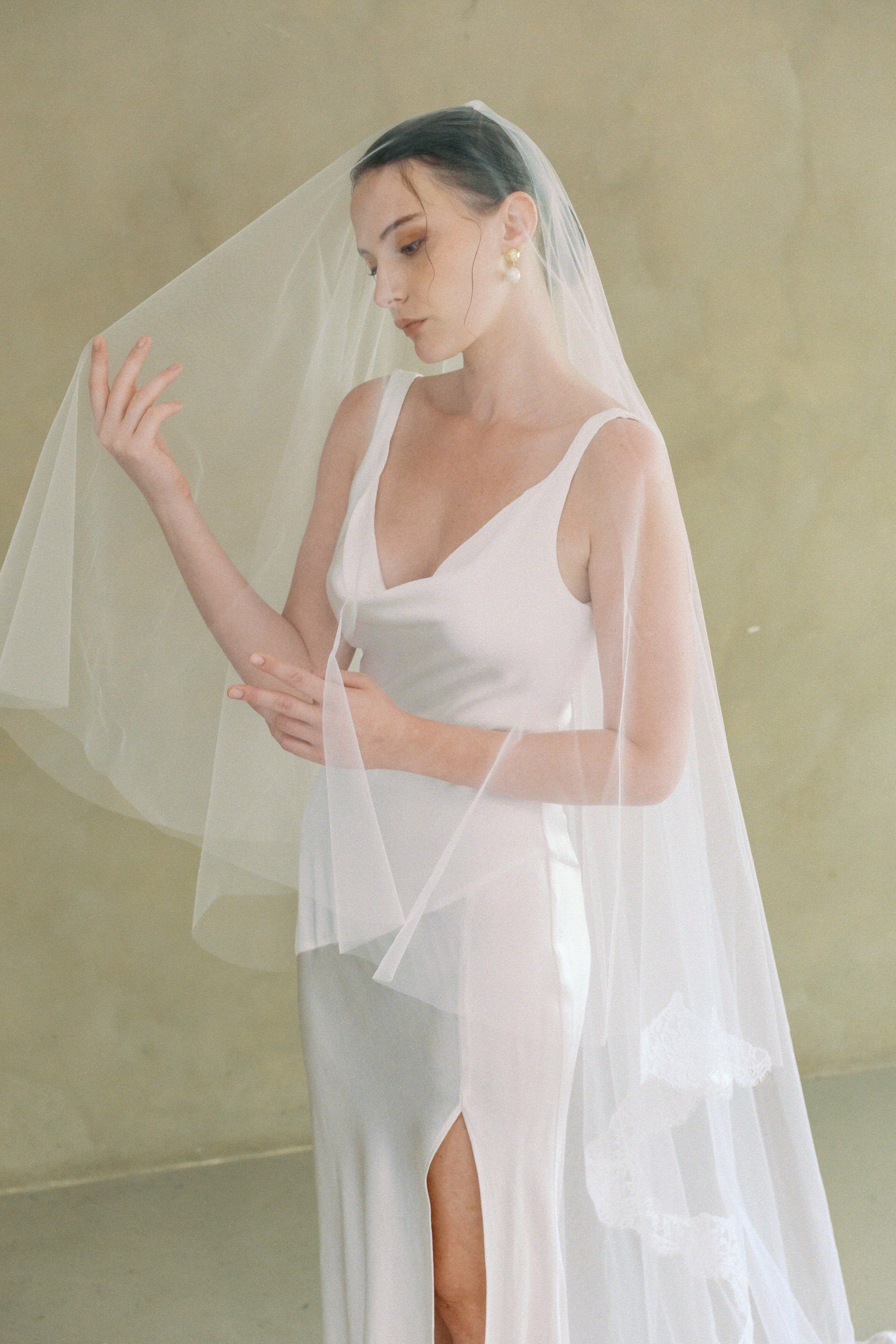 model wears a drop veil with partial lace trim