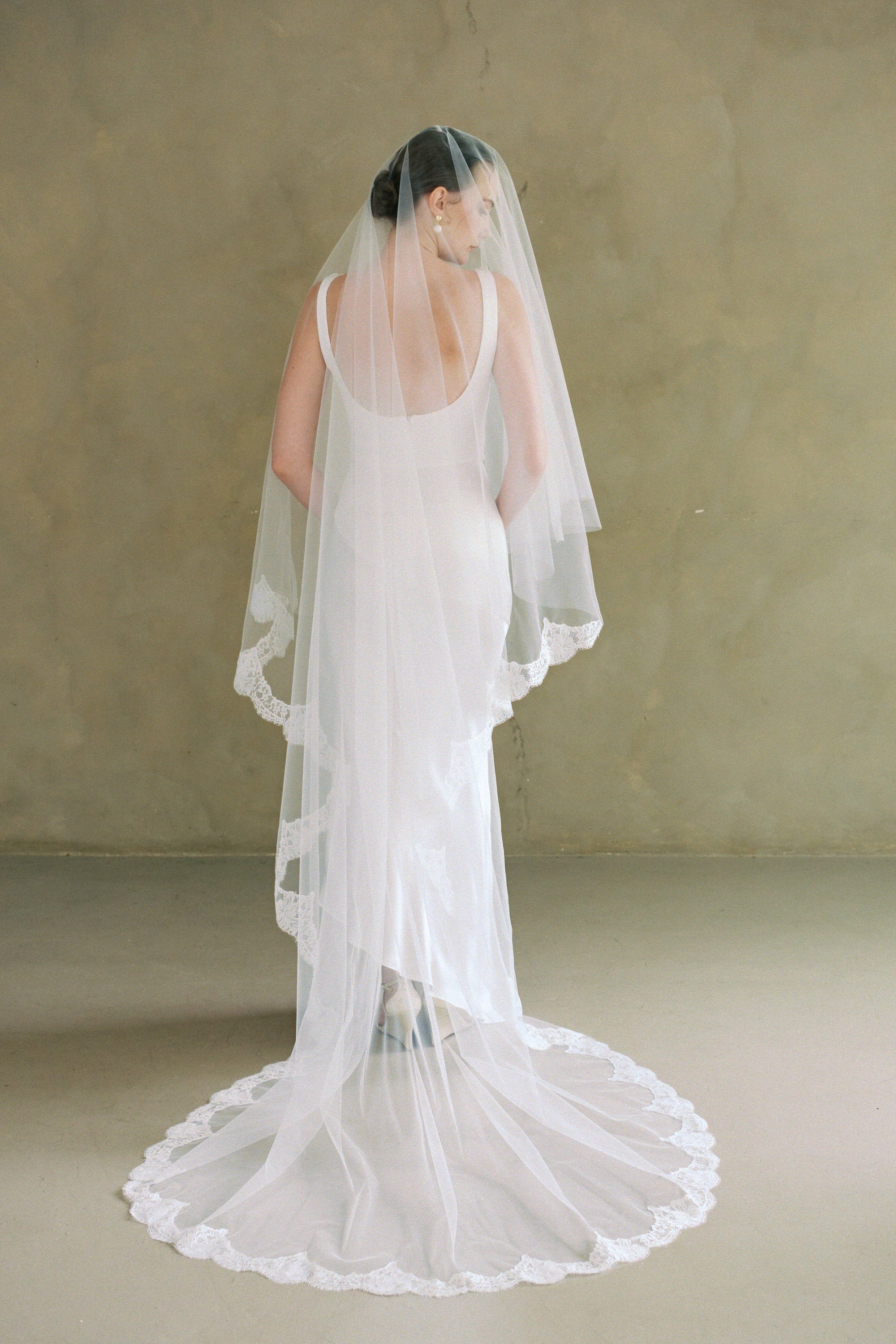 model wears a drop veil with partial lace trim