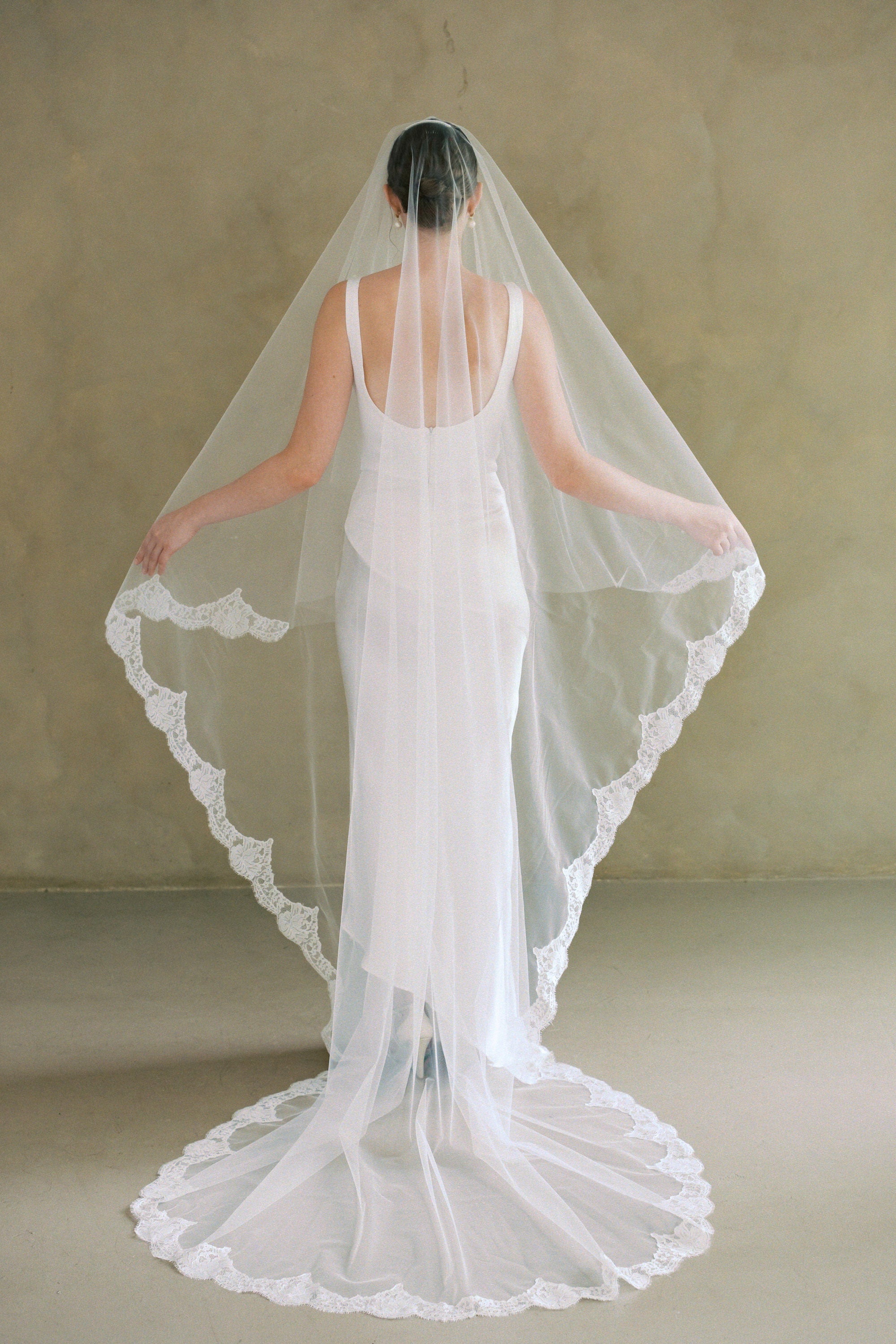 model wears a drop veil with partial lace trim