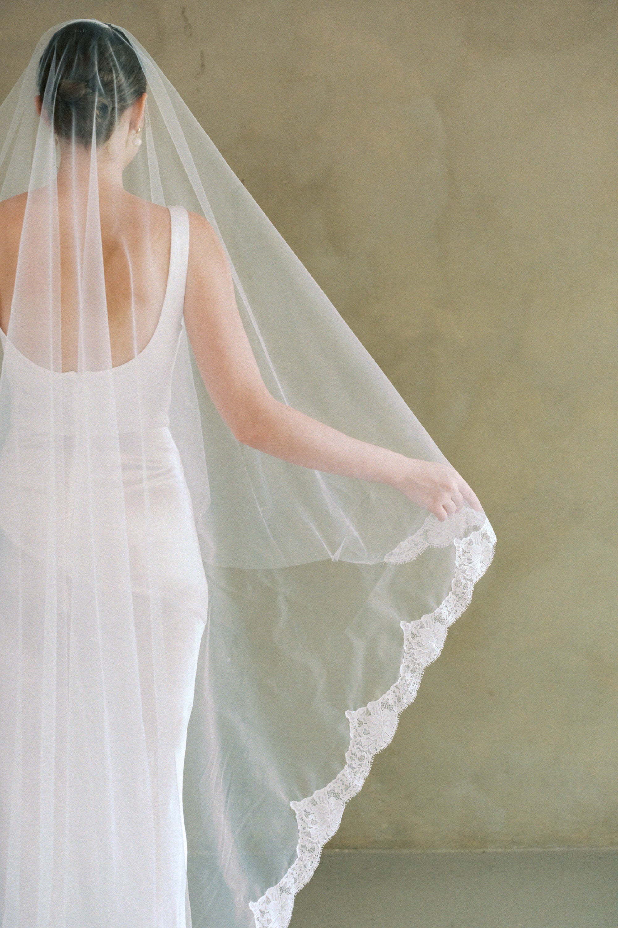model wears a drop veil with partial lace trim