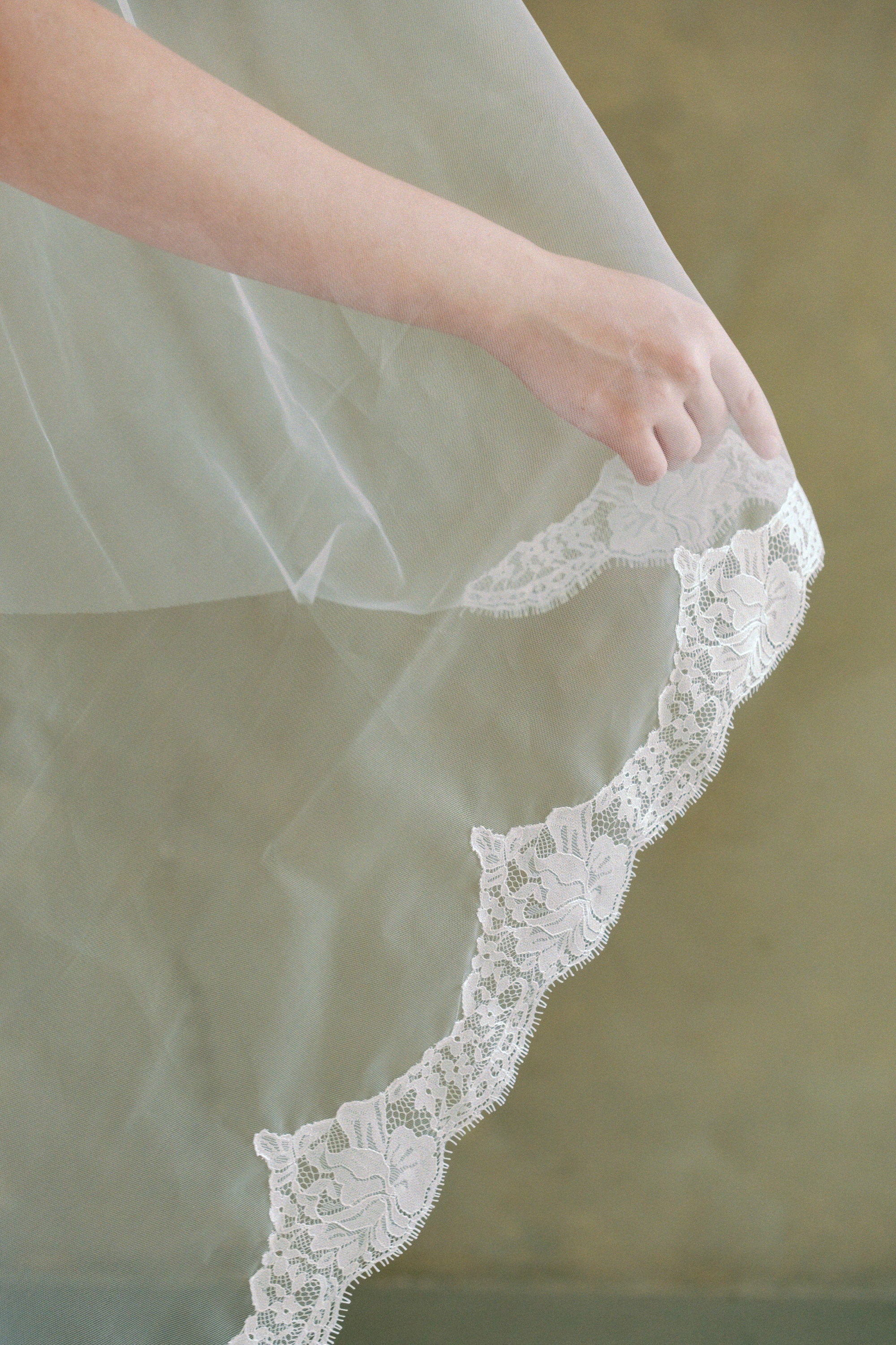 model wears a drop veil with partial lace trim