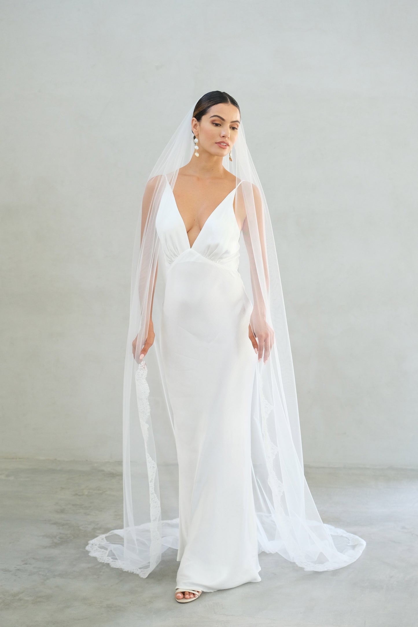 model wears one tier veil with partial lace trim, lace edged wedding veil