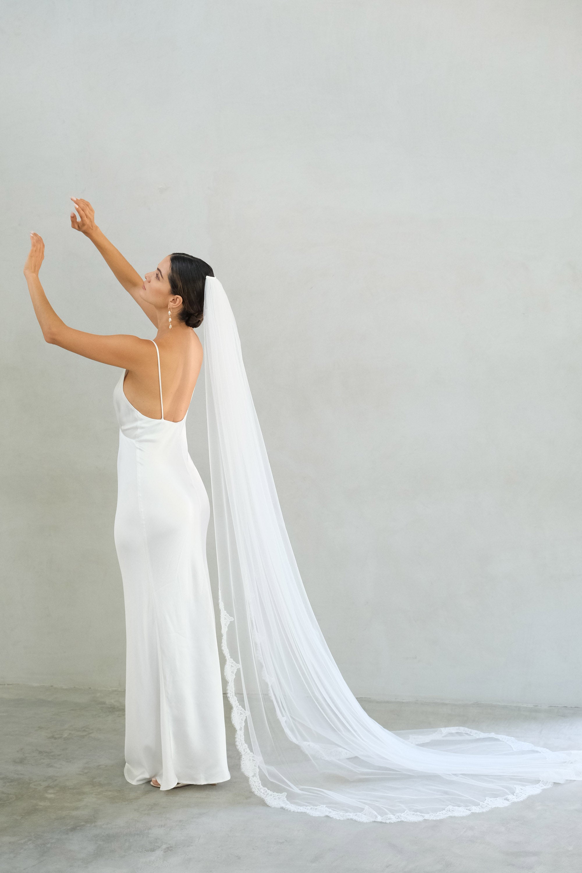 model wears one tier veil with partial lace trim, lace edged wedding veil