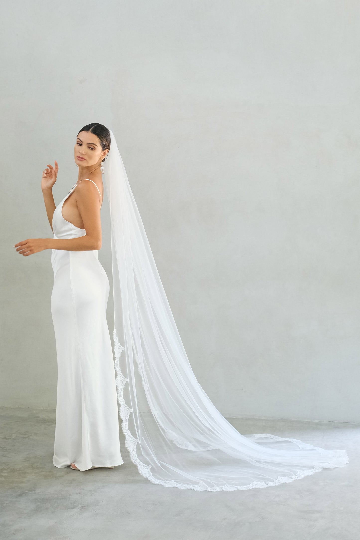 model wears one tier veil with partial lace trim, lace edged wedding veil