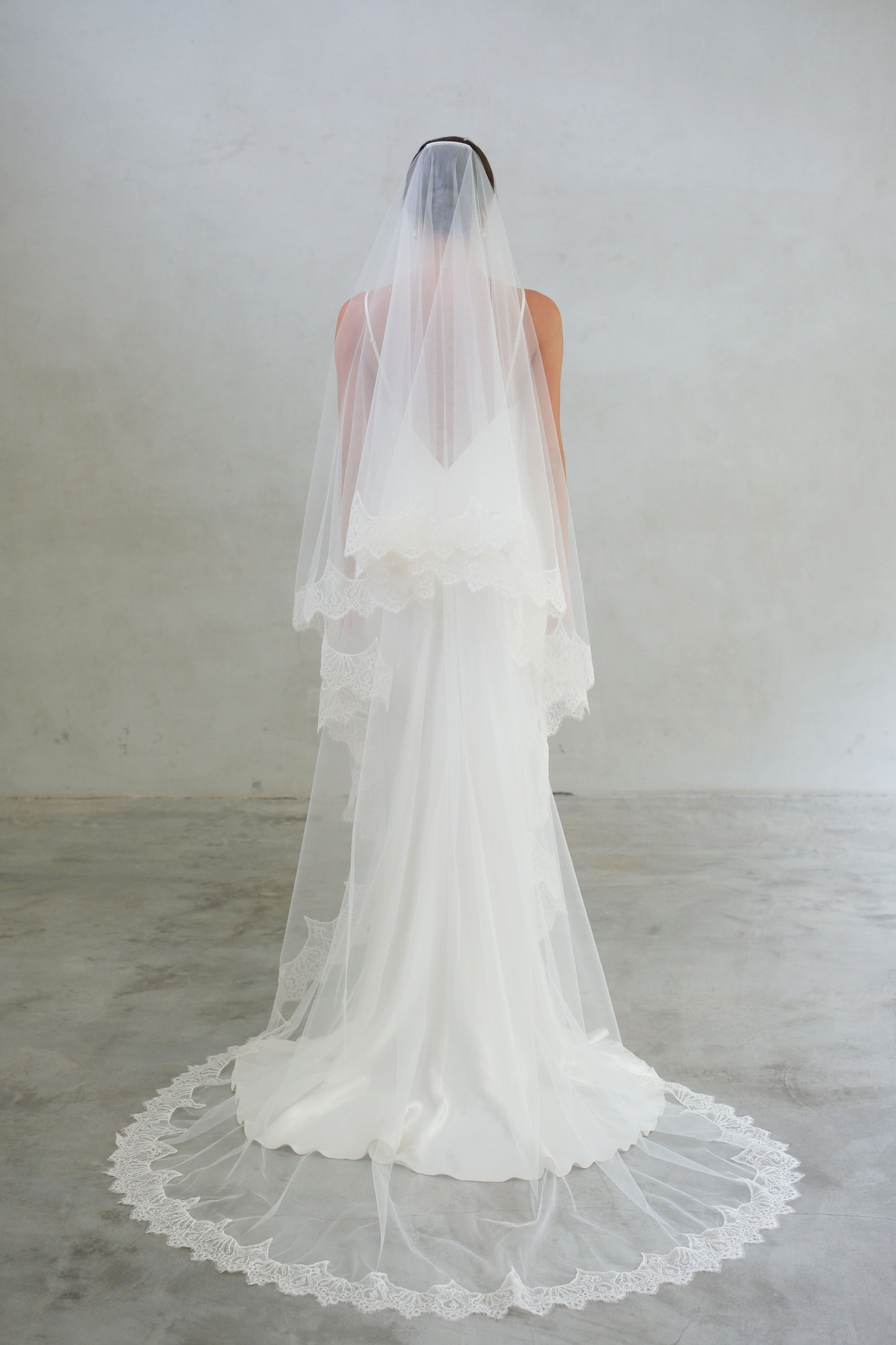Full length back view showing lace edge two tier wedding veil in chapel length
