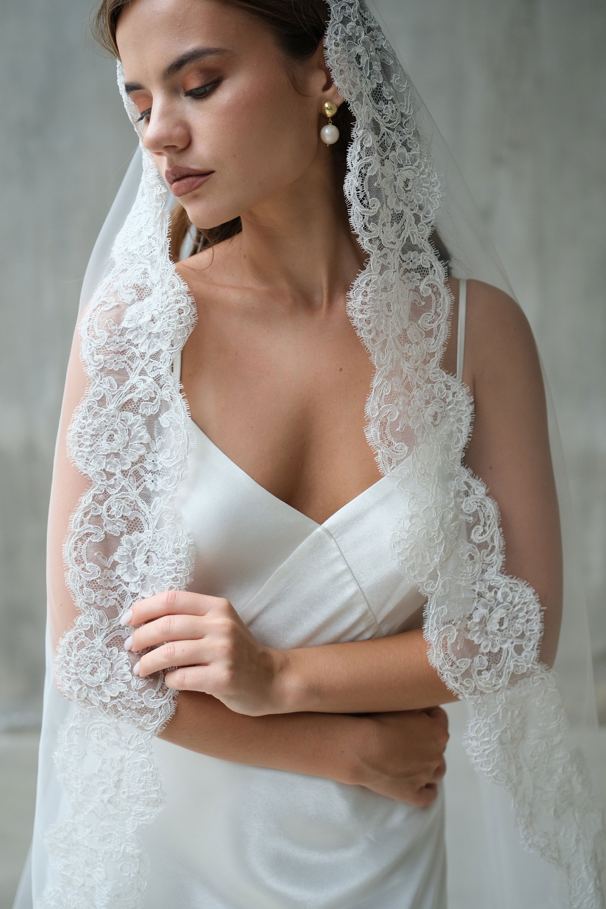 Front facing head and shoulders shot highlighting corded lace detail on edges of long one tier bidal veil