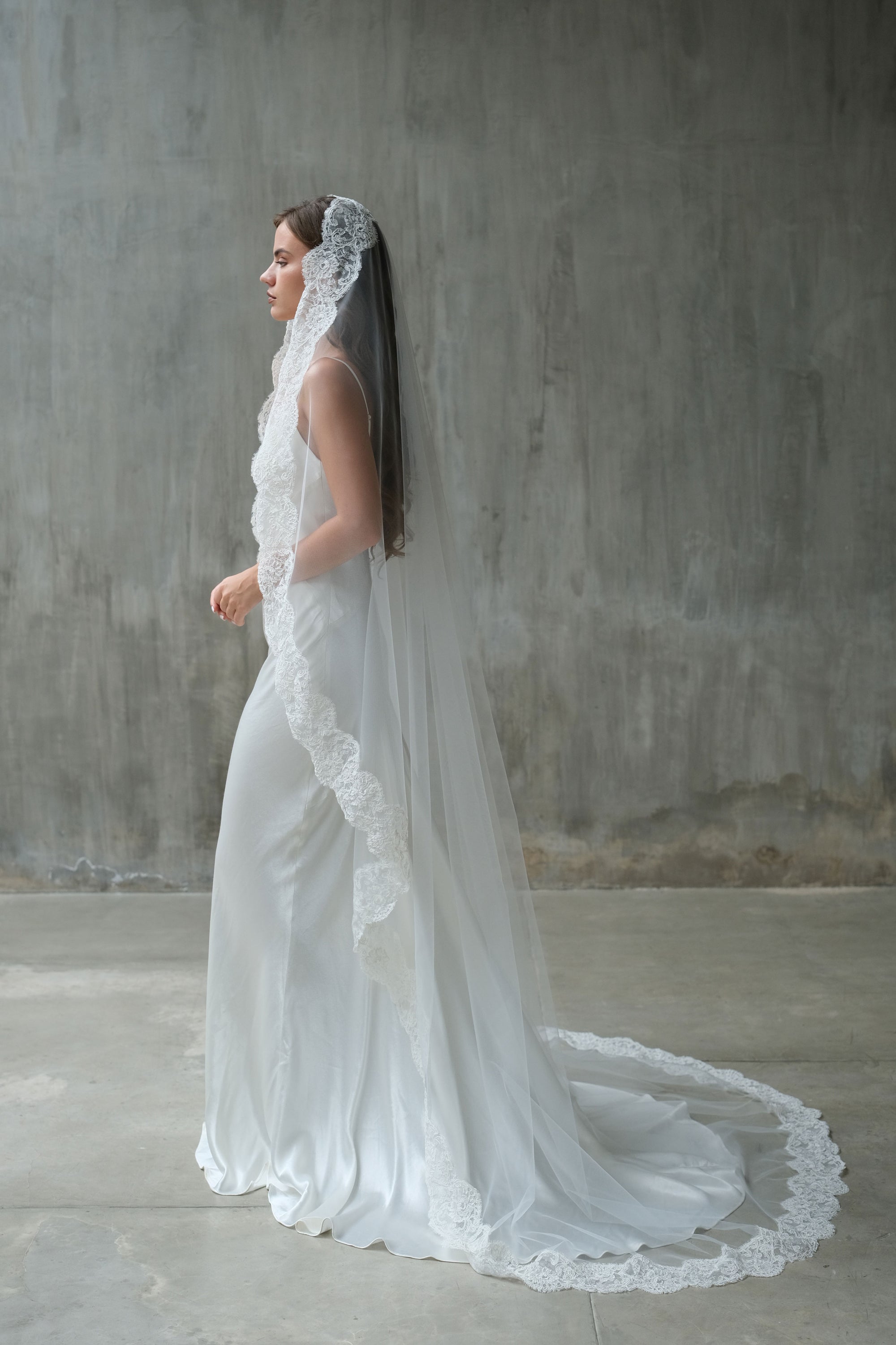 Full length side view of long, lace trimmed mantilla style bridal veil