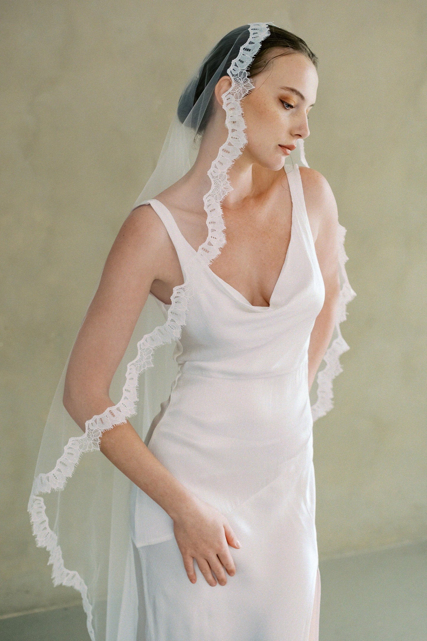 Model wears long one-tier lace trim Mantilla veil by Madame Tulle
