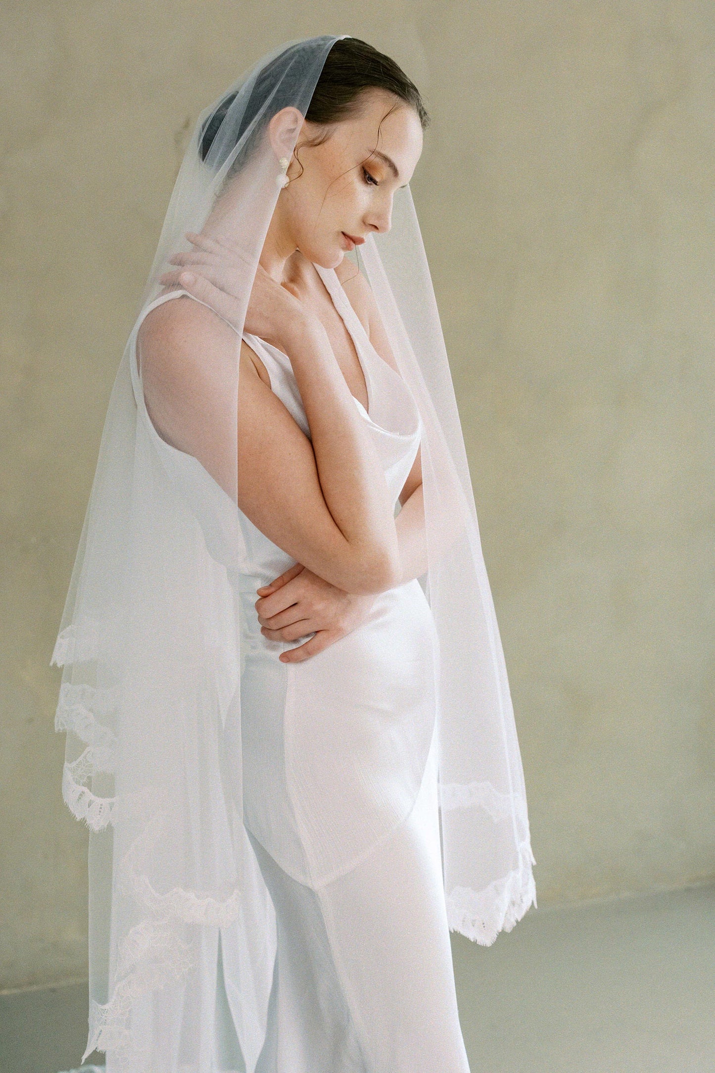 Model wears drop veil, two-tier Mantilla lace trim wedding veil shown with blusher off