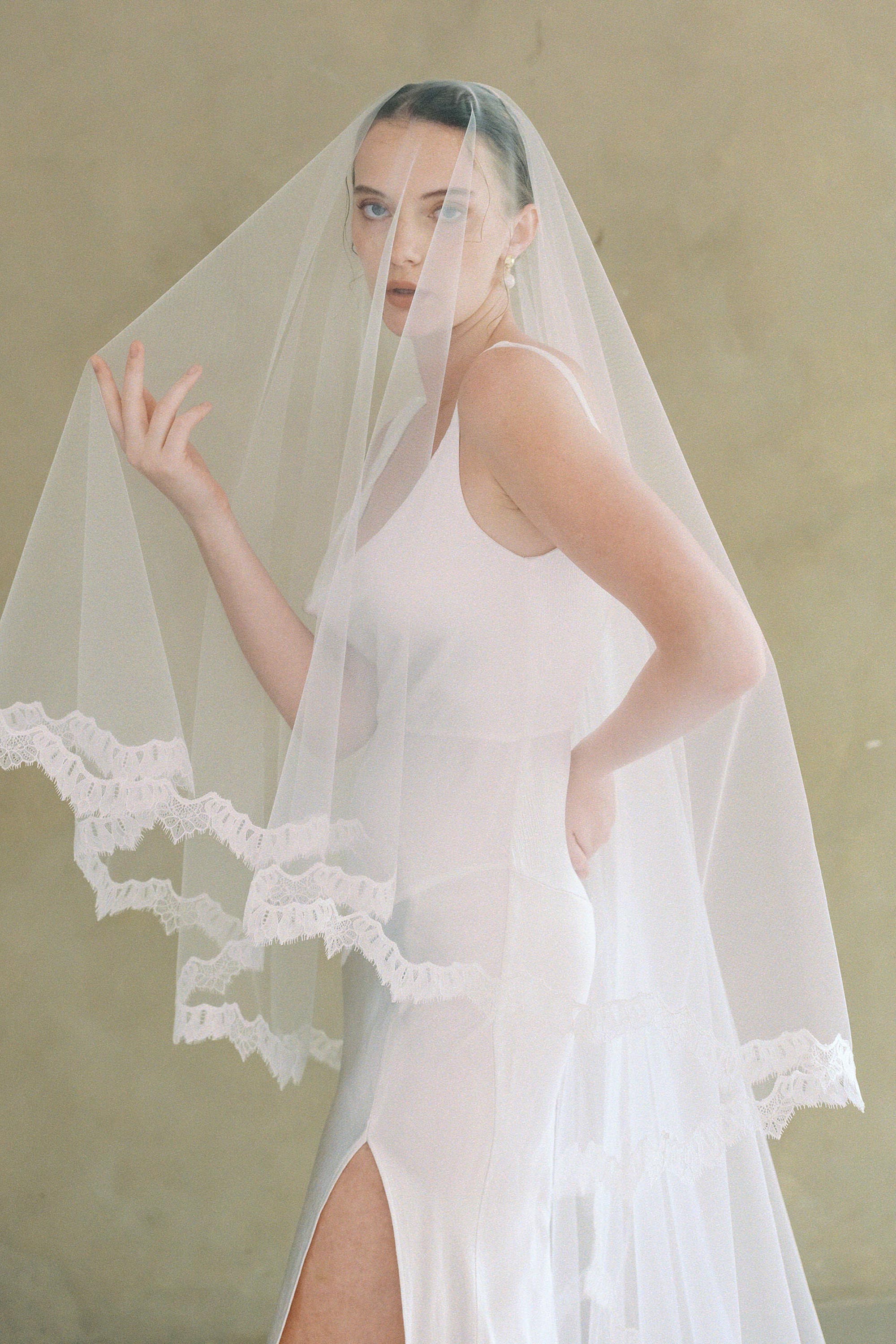 model wears drop veil, two-tier Mantilla lace trim wedding veil