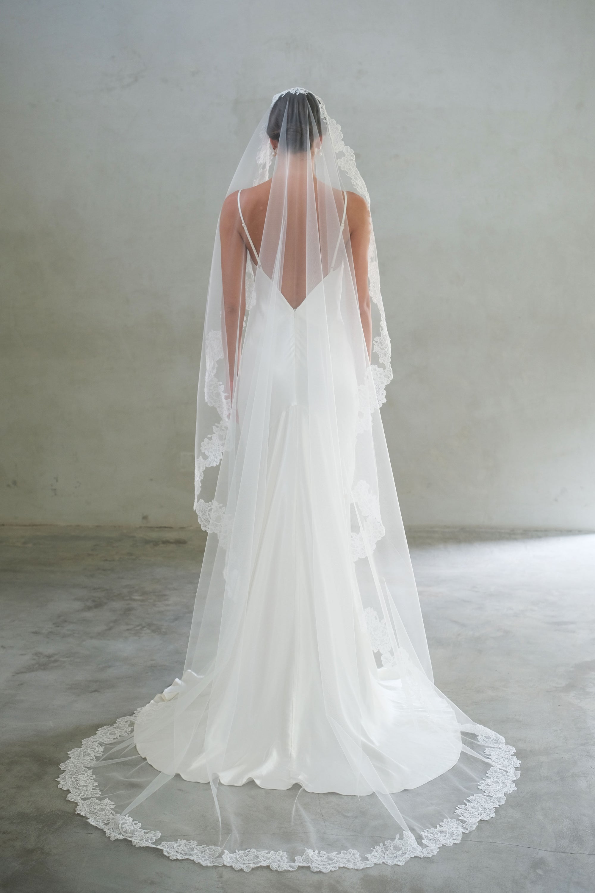 Full length back view of long, lace trimmed mantilla bridal veil