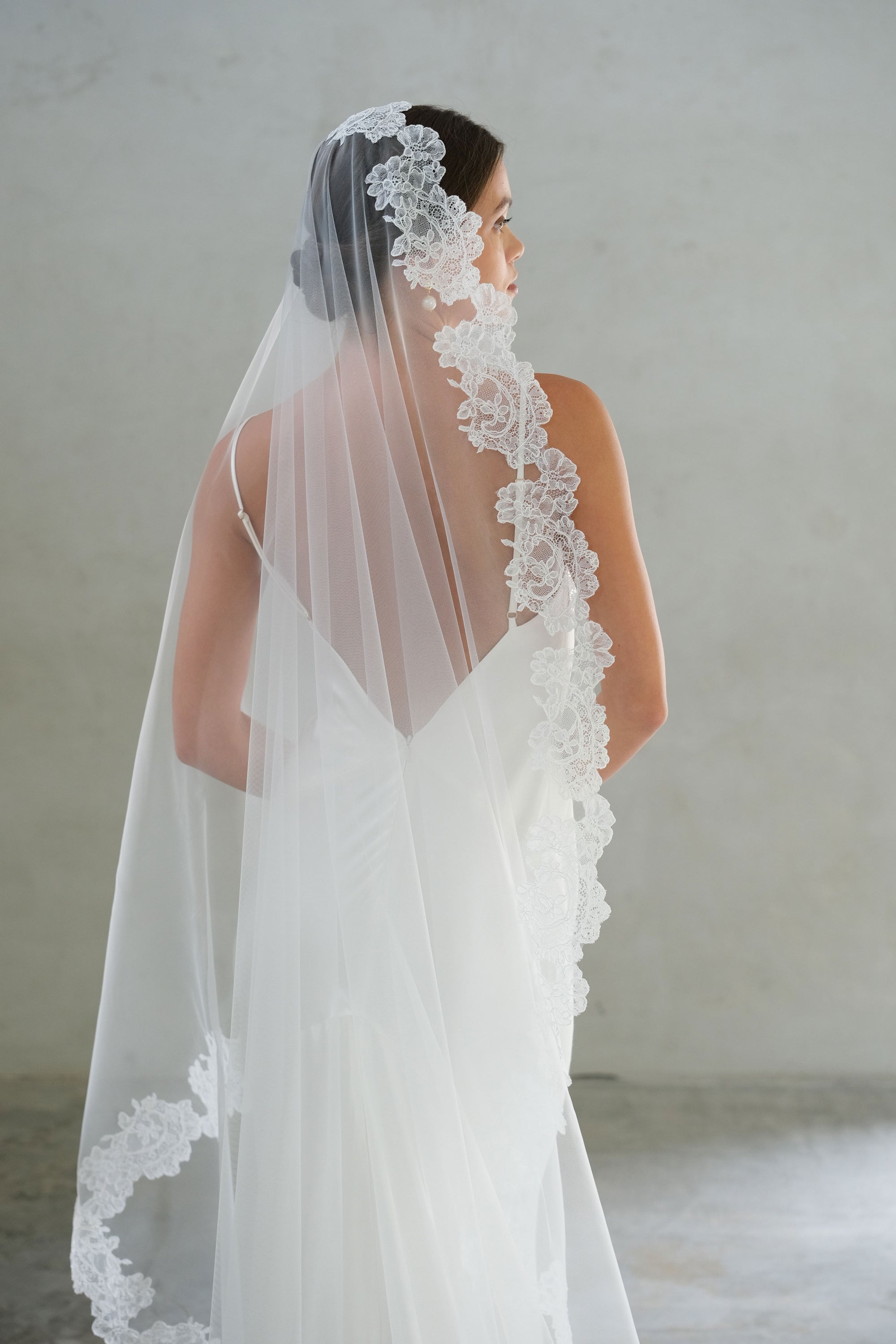Half length back view showing lace trimmed mantilla bridal veil
