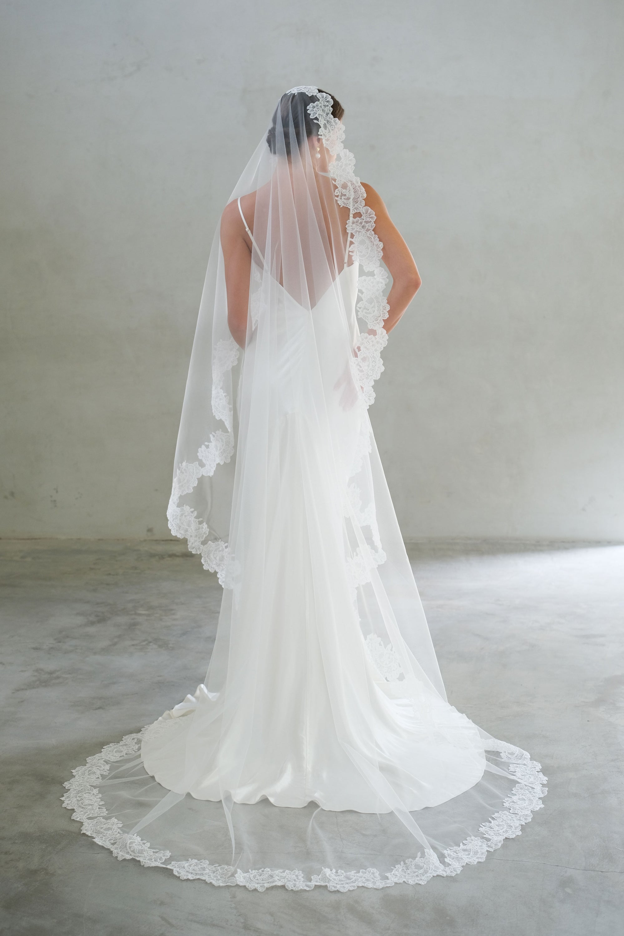 Full length back view of chapel length laced trimmed mantilla veil