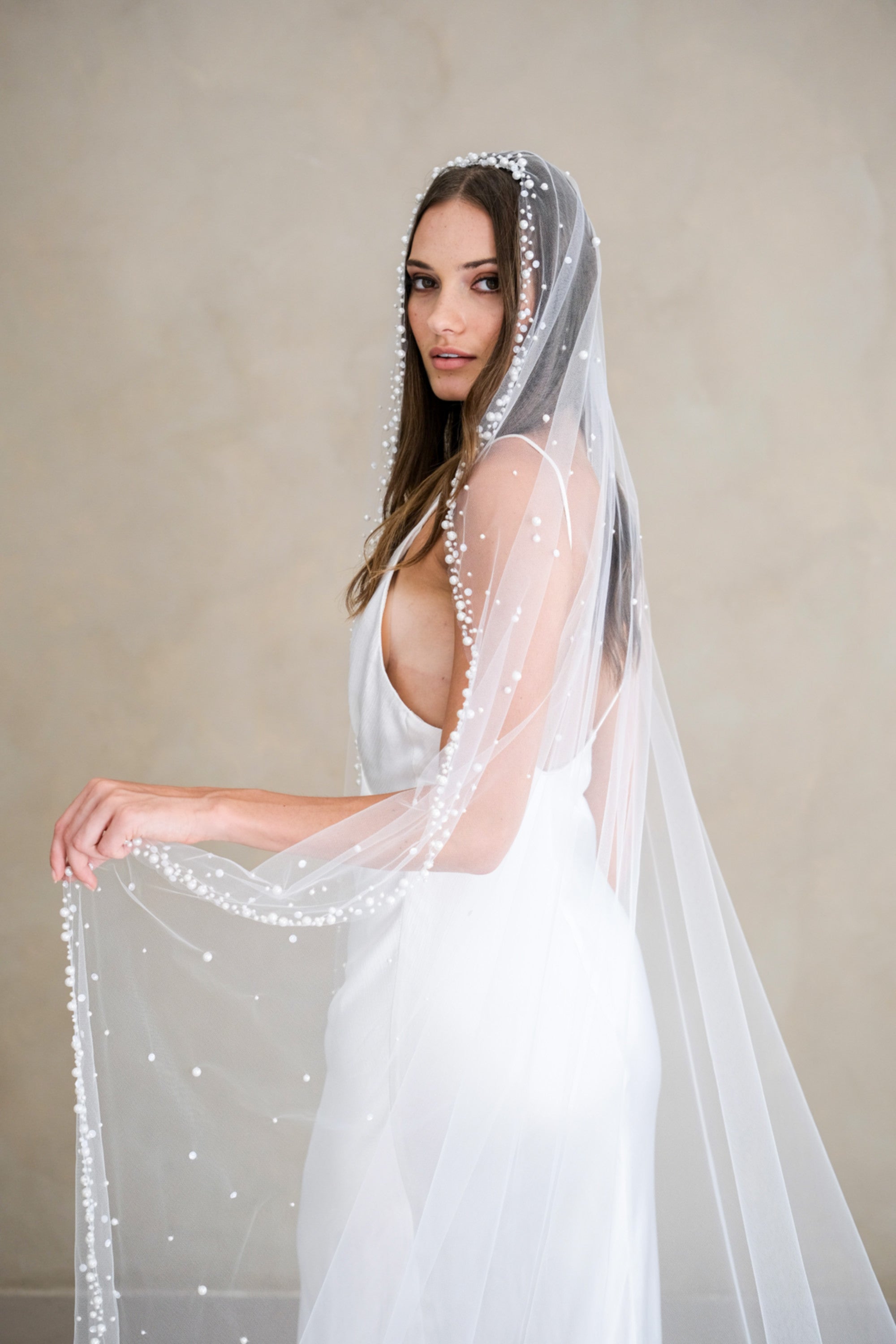Model wears a wedding veil, one tier veil with pearls and sequins
