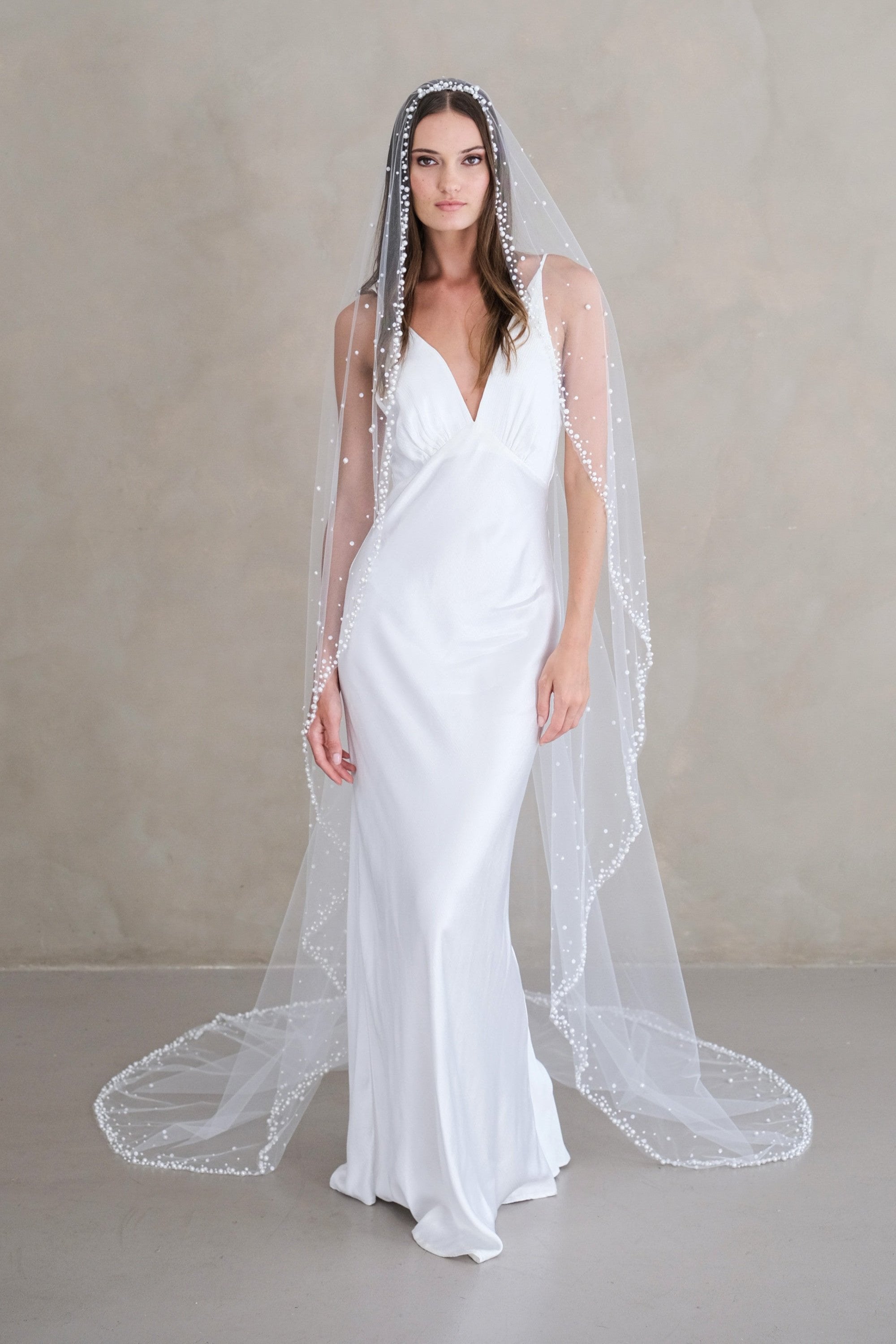 Model wears a wedding veil, one tier veil with pearls and sequins