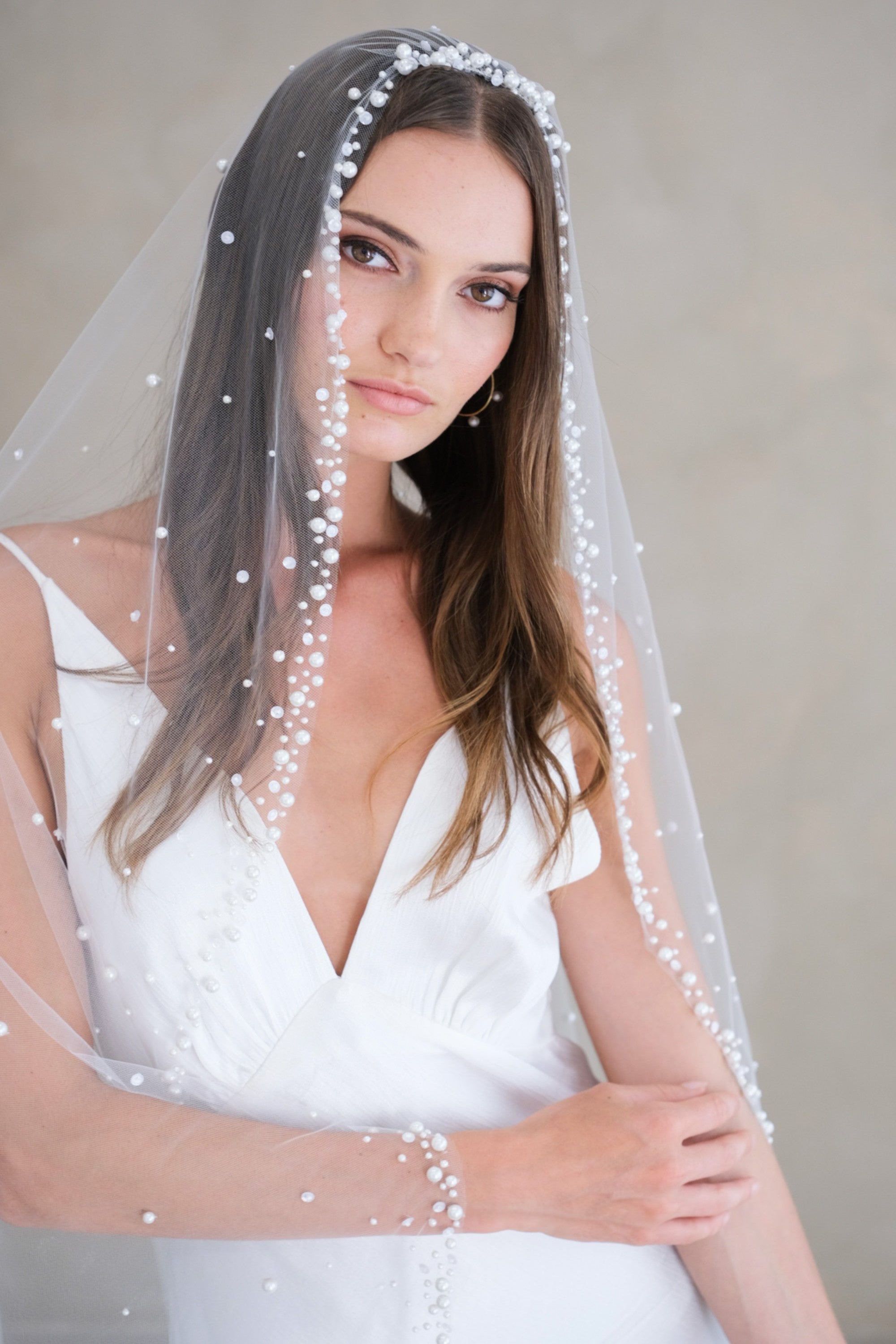 Model wears a wedding veil, one tier veil with pearls and sequins