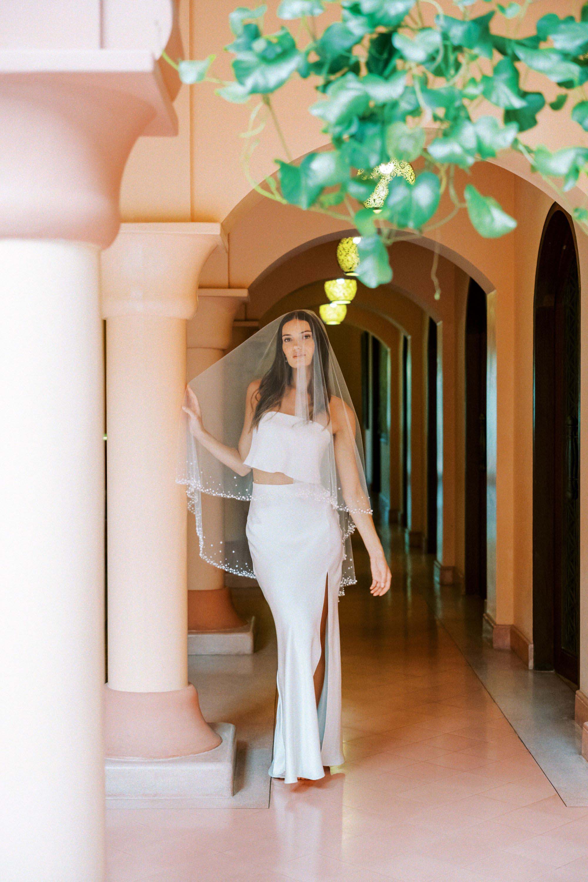 Model wears a two-tier wedding veil, drop veil with pearls and sequins