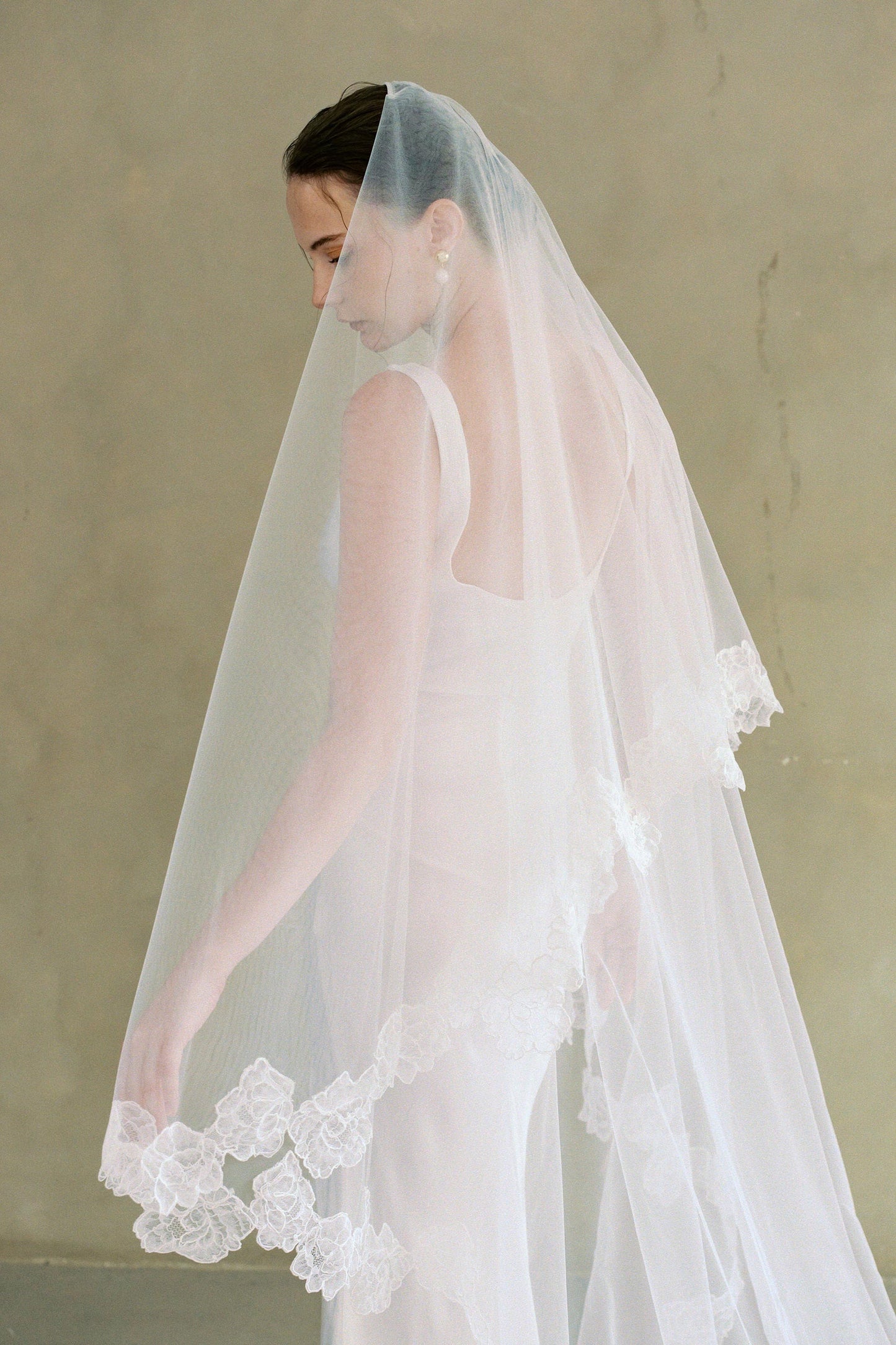 Model wears two-tier lace trim wedding veil by Madame Tulle