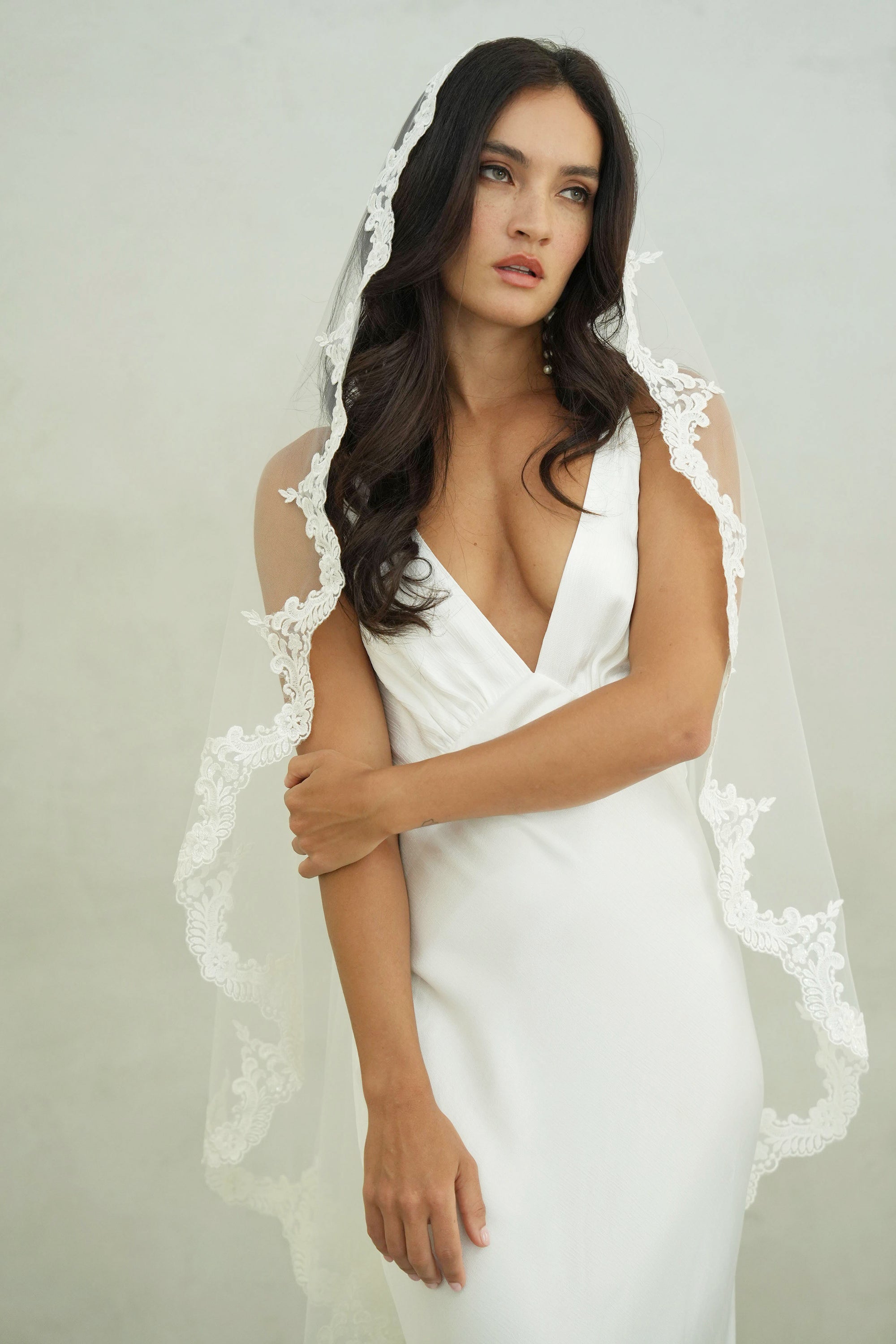 model wears mantilla veil, one-tier lace trim wedding veil