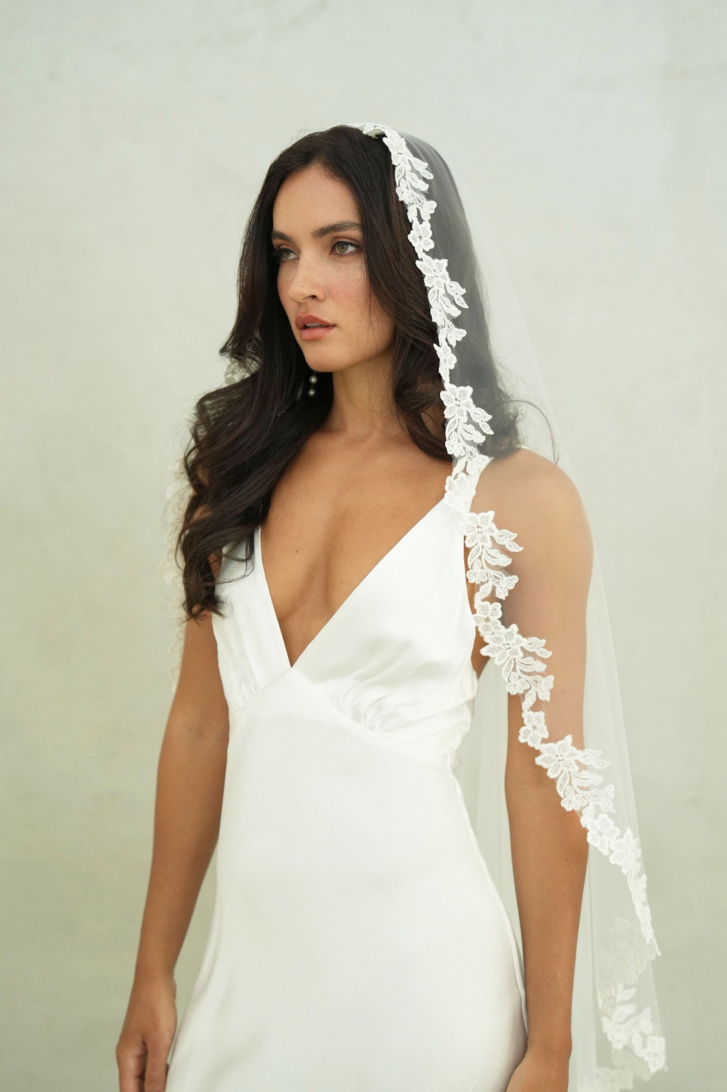 Bride models mantilla lace trimmed wedding veil