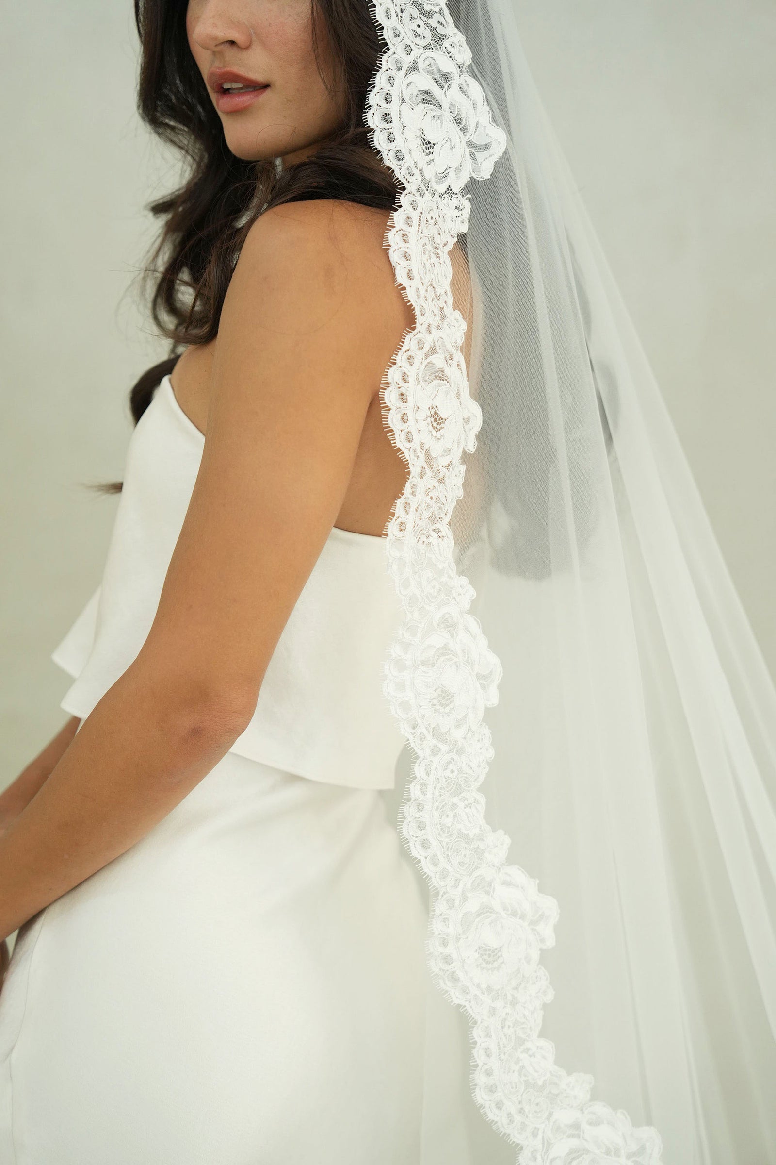 model wears mantilla veil, one-tier lace trim wedding veil