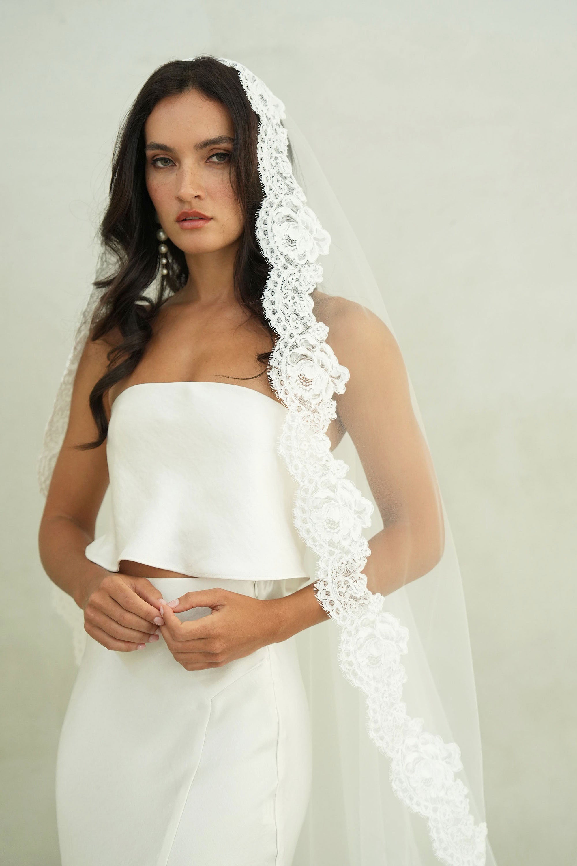 model wears mantilla veil, one-tier lace trim wedding veil