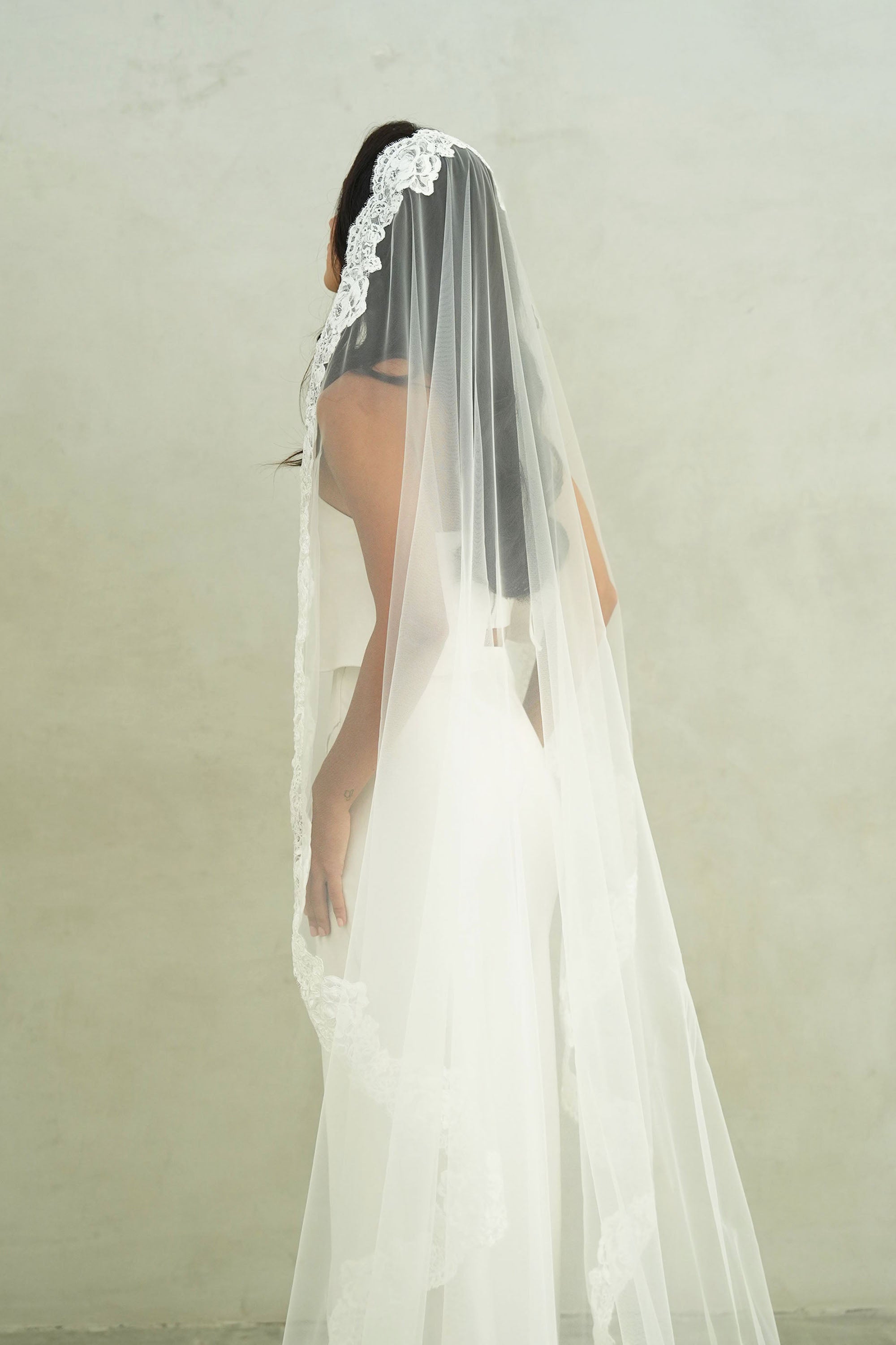 model wears mantilla veil, one-tier lace trim wedding veil