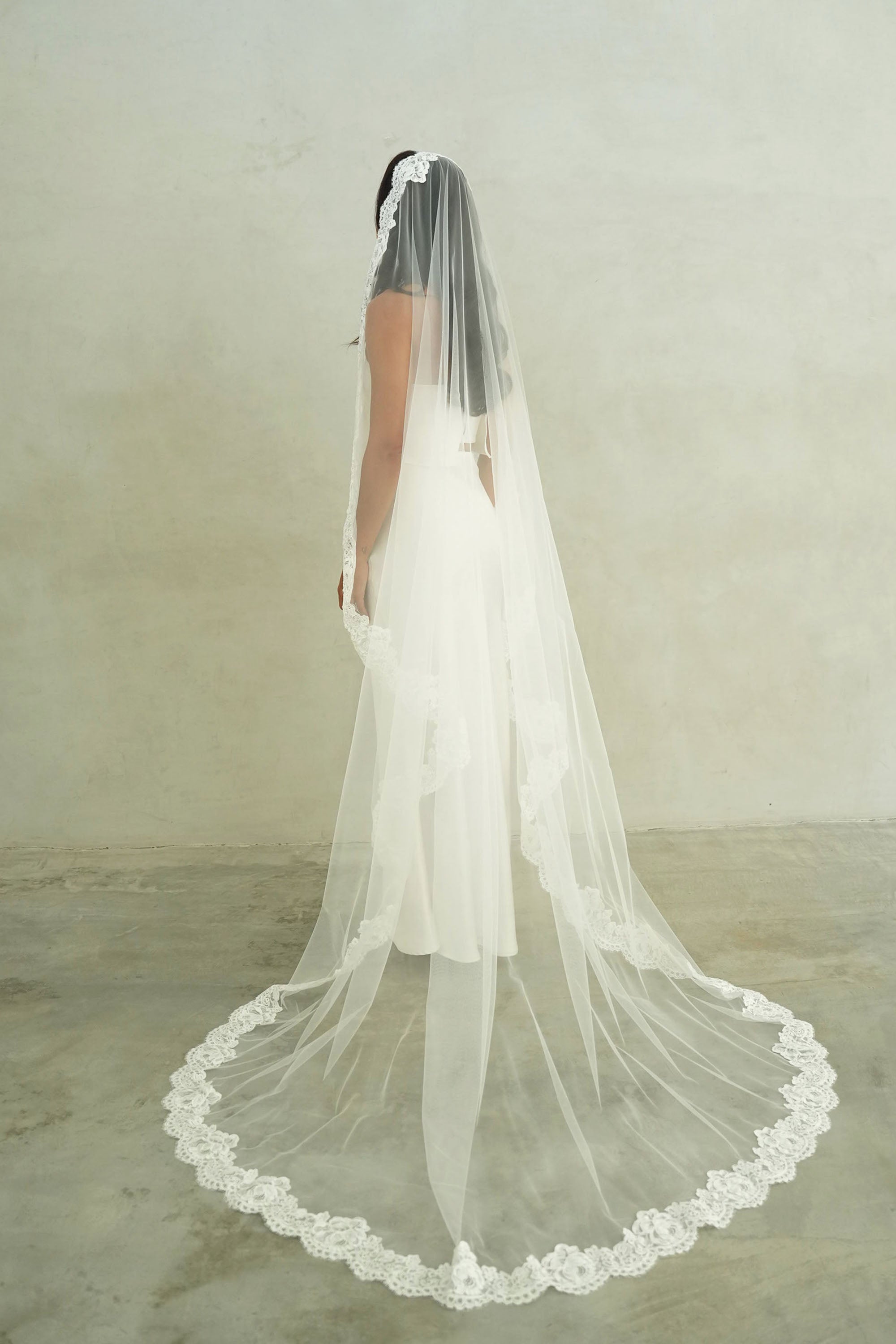 model wears mantilla veil, one-tier lace trim wedding veil