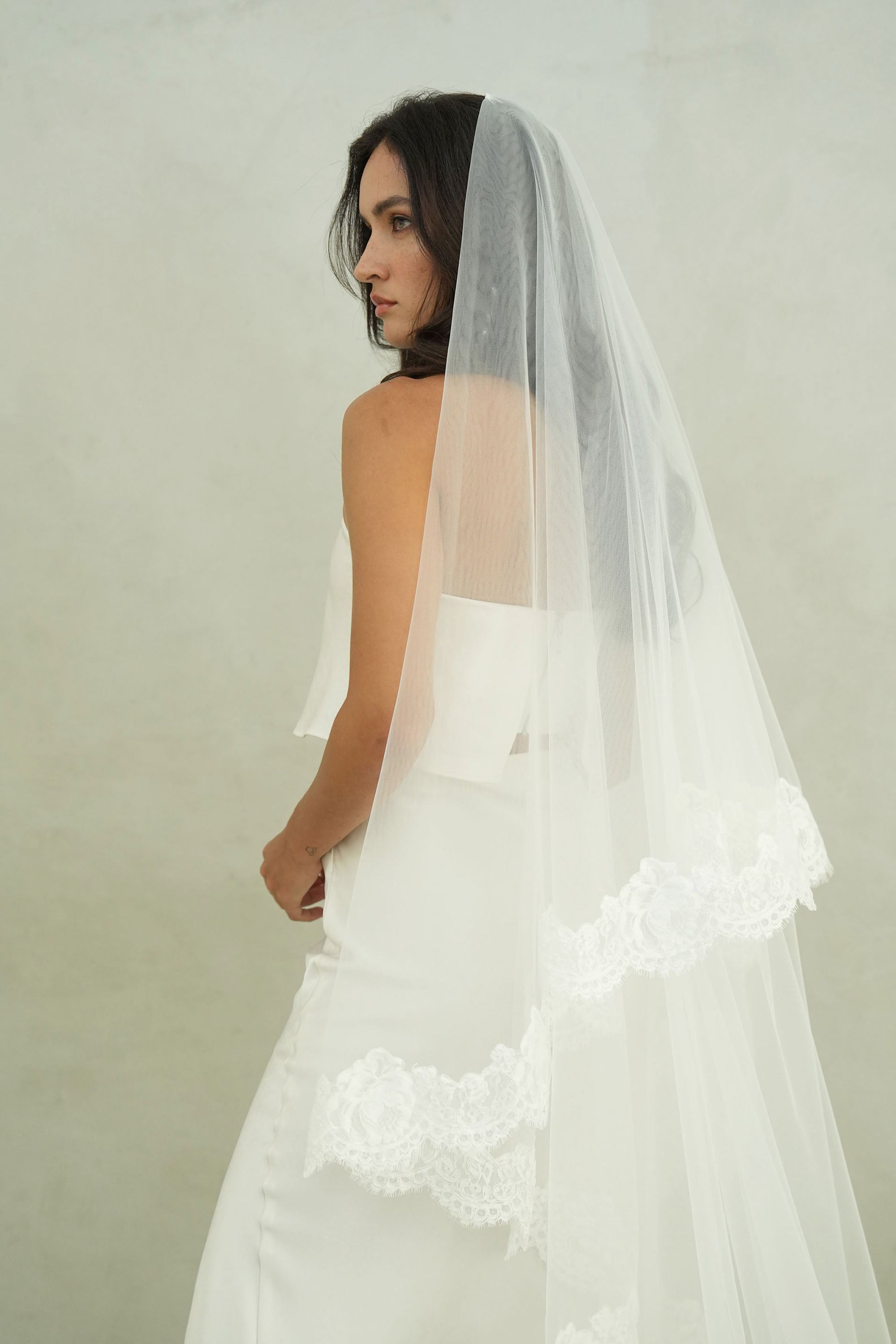 model wears mantilla veil, drop lace trim wedding veil