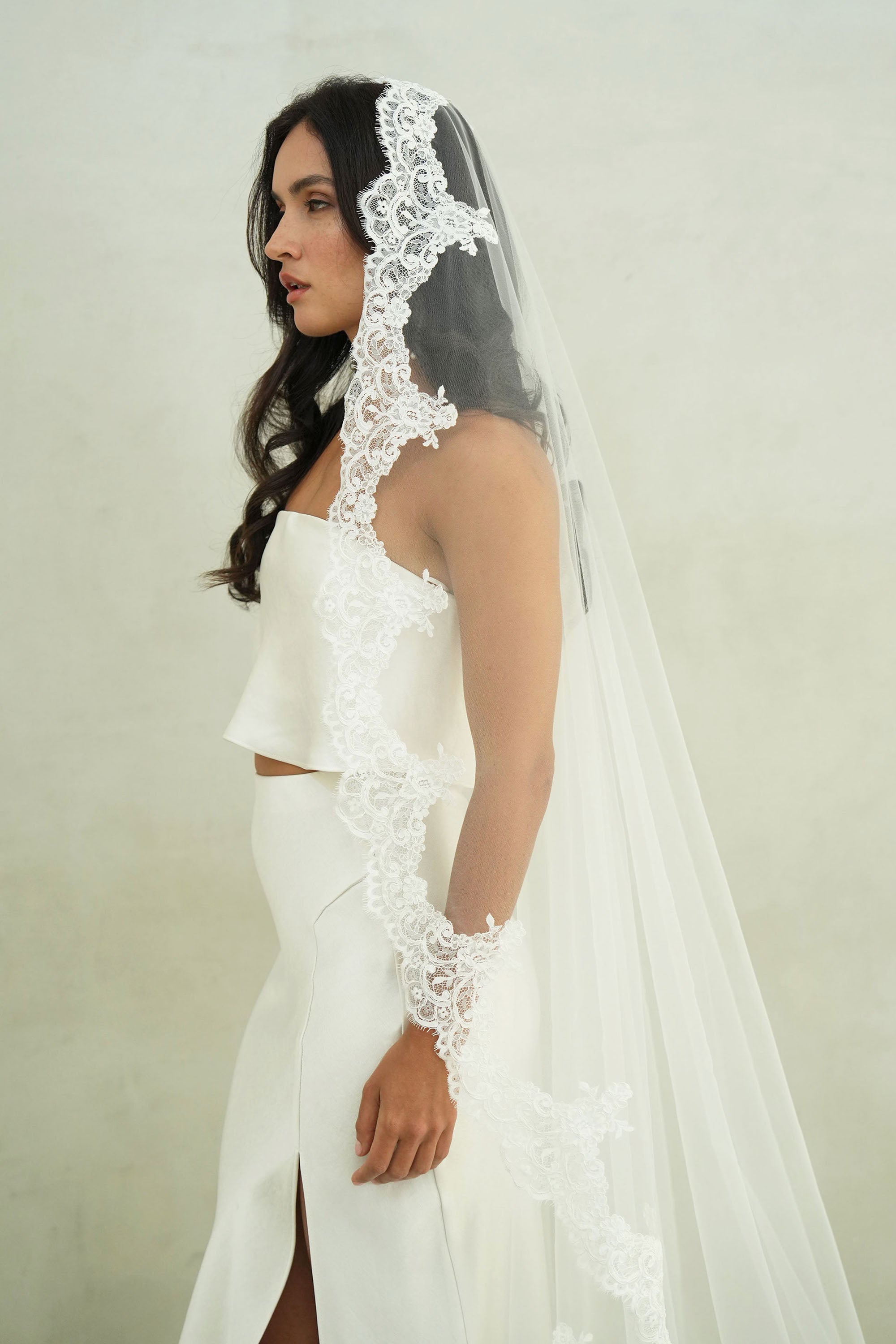 model wears mantilla veil, one-tier lace trim wedding veil