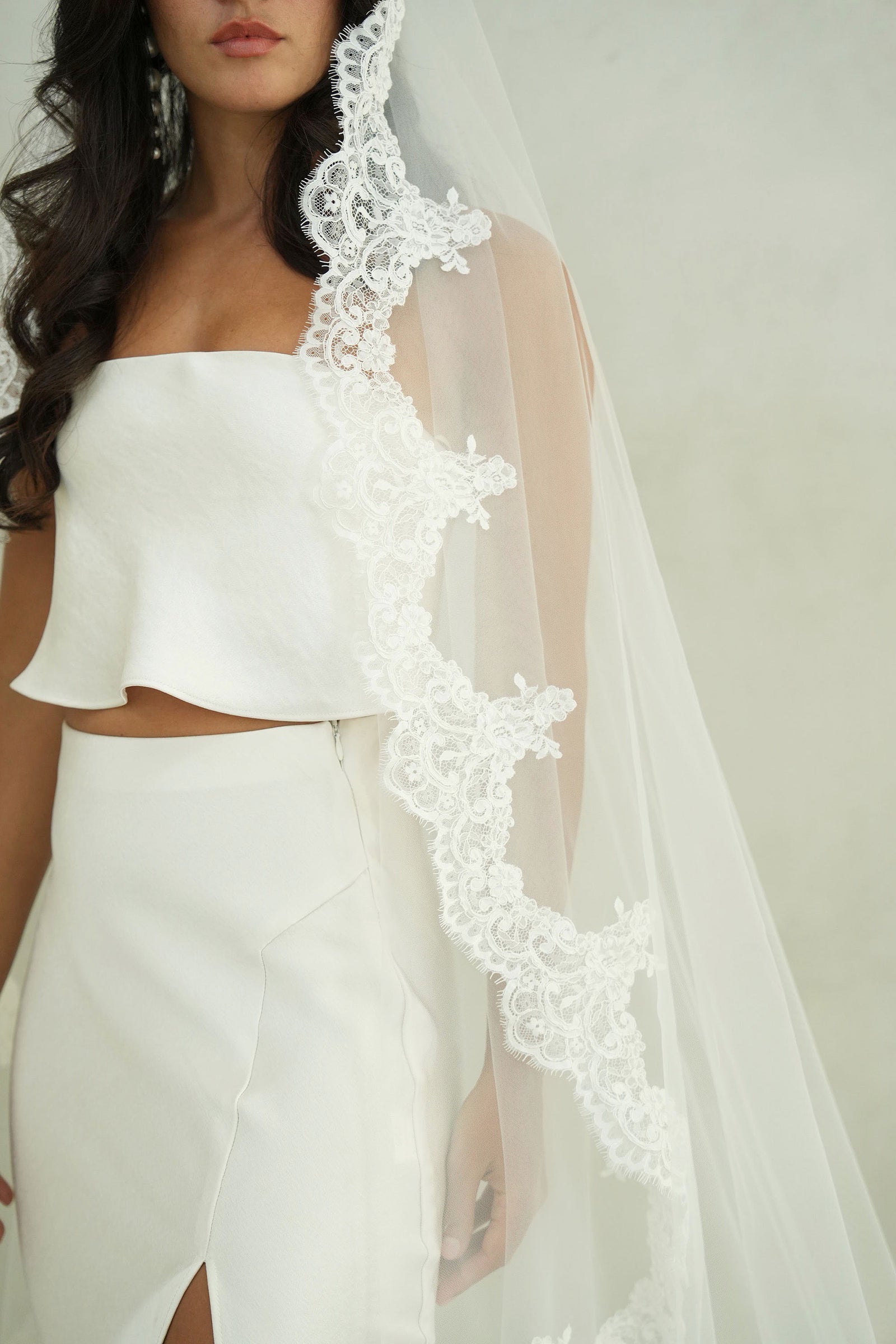 model wears mantilla veil, one-tier lace trim wedding veil