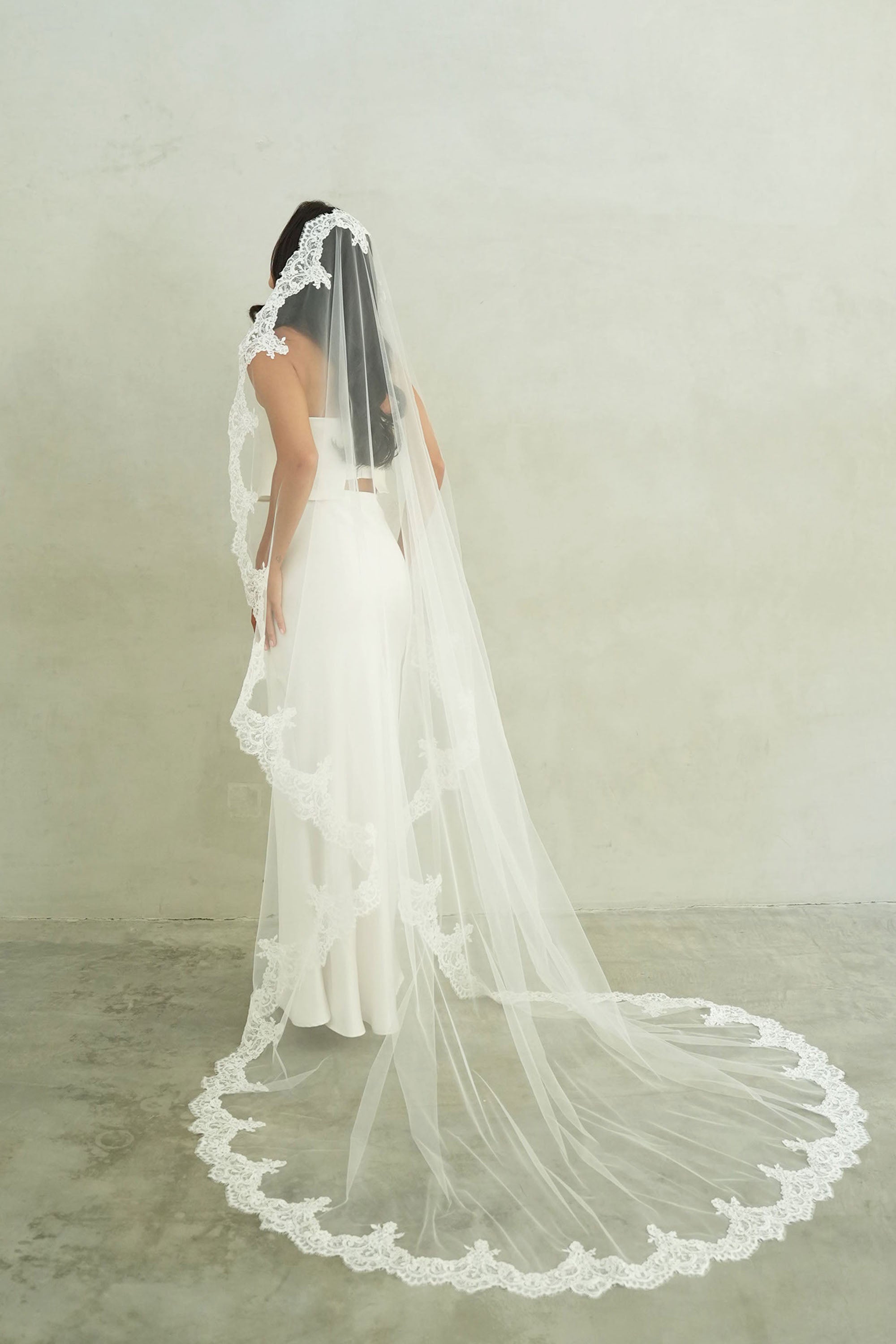model wears mantilla veil, one-tier lace trim wedding veil