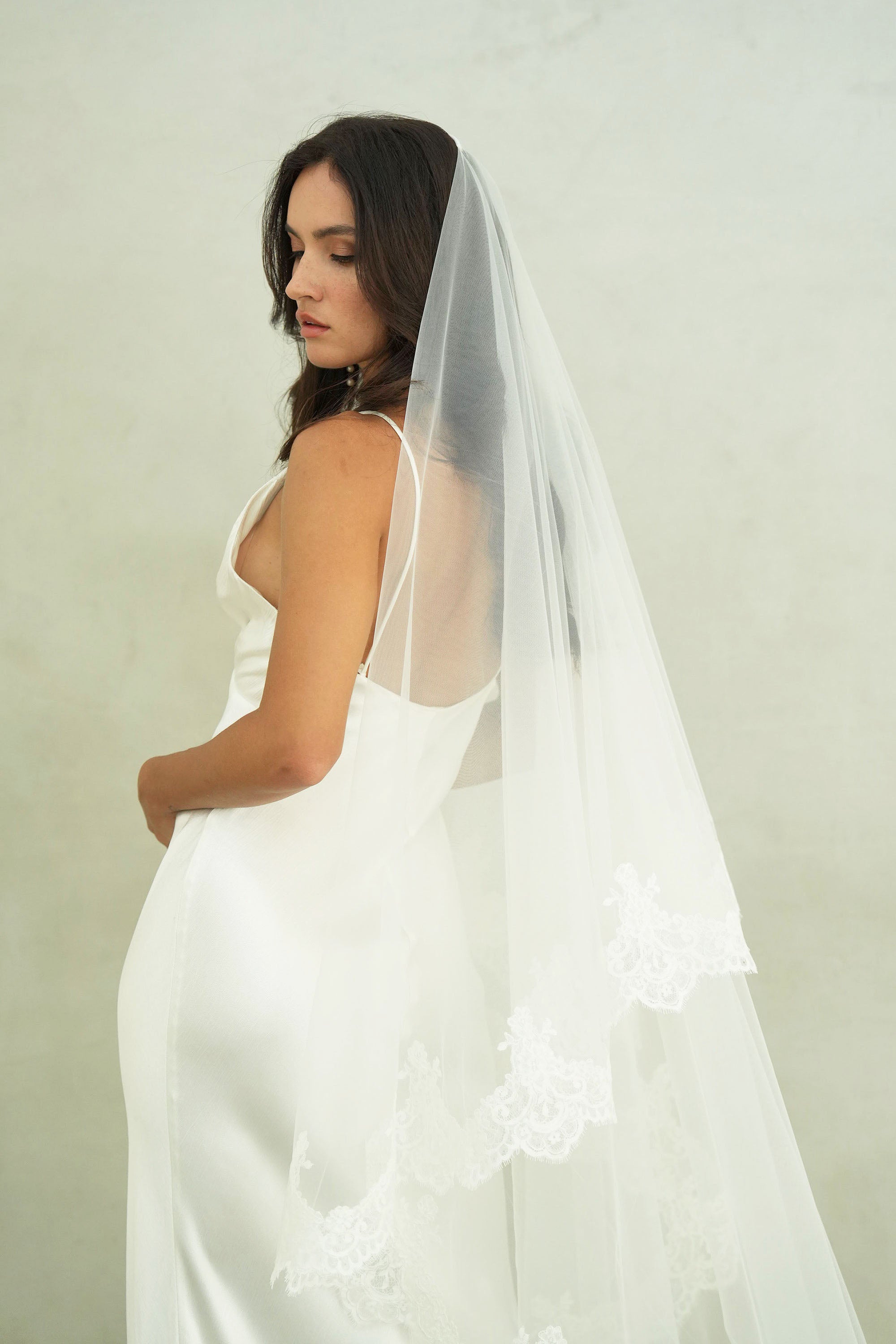 model wears a mantilla lace trim veil, drop lace edged wedding veil